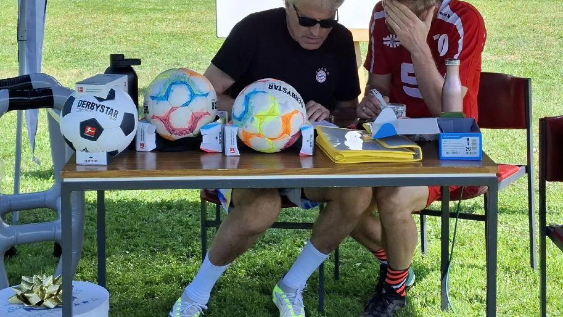 Schiedsrichter diskutieren am Tisch beim Fußball-Turnier