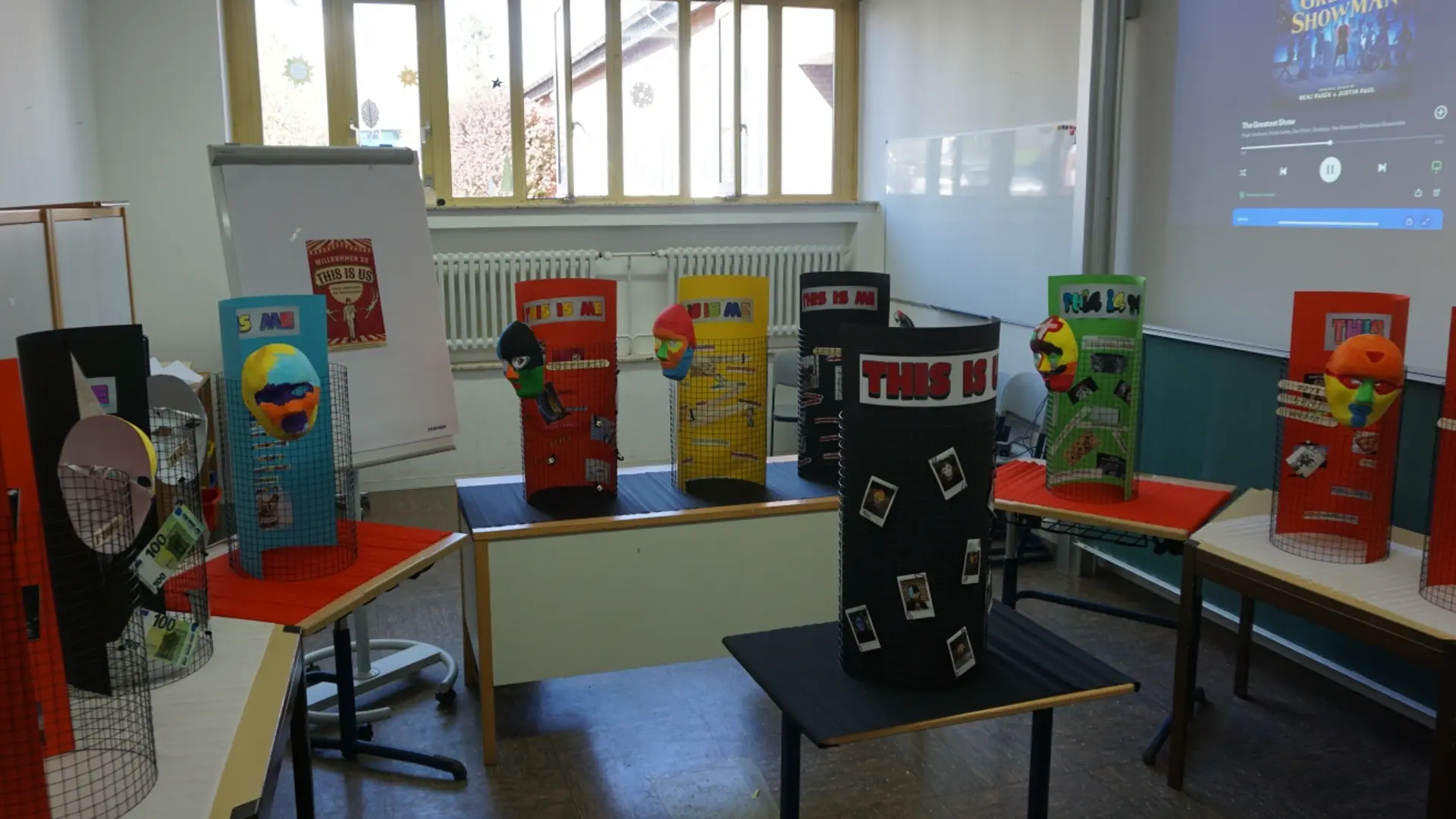 In der Projektwoche hergestellte Projekte der Schüler*innen zur Selbstdarstellung aufgereiht im Klassenzimmer beim Tag der offenen Tür