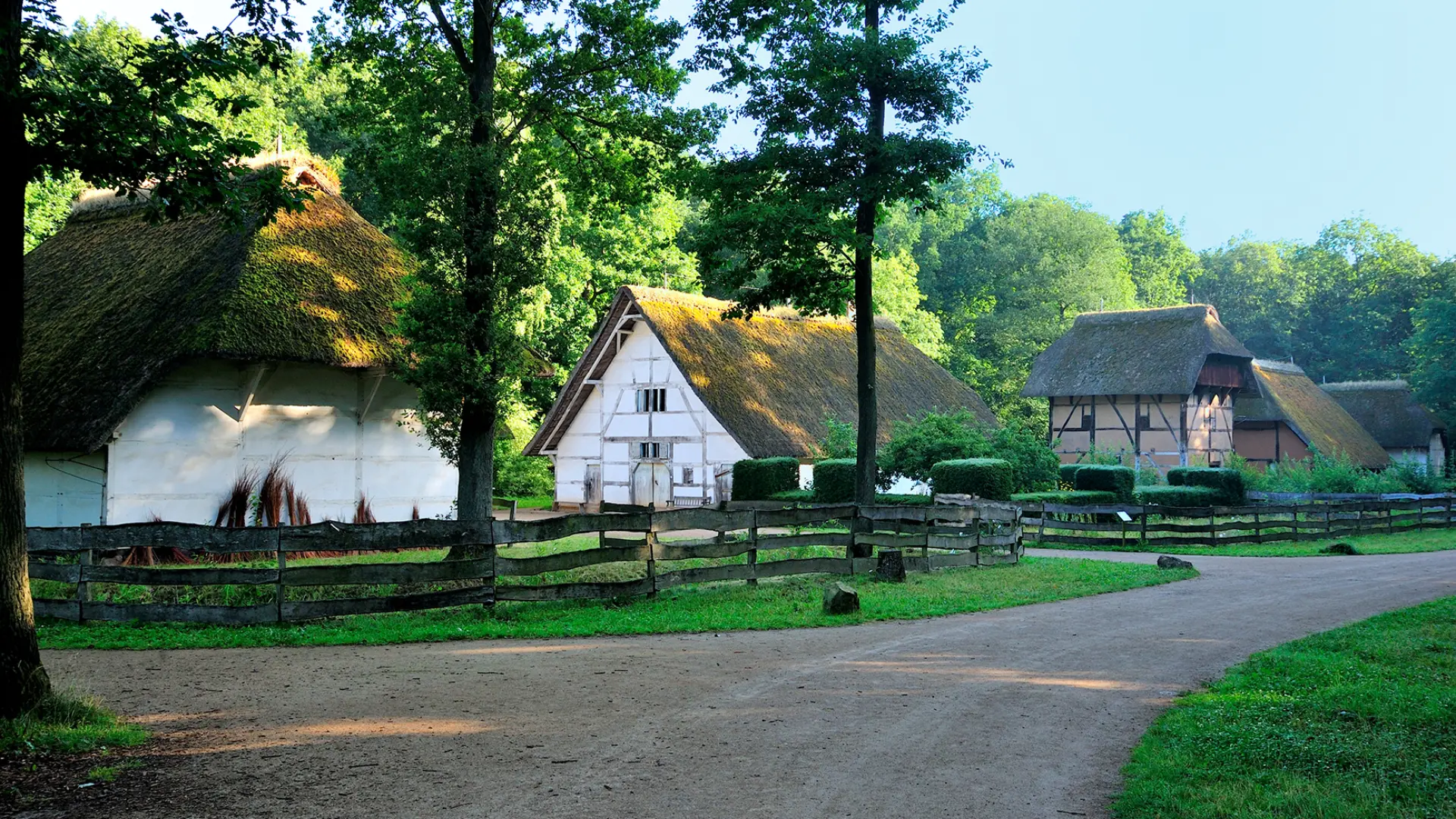 Foto: Straße in die Baugruppe Niederrhein mit drei Fachwerkhäusern auf der linken Seite hinter Bohlenzäunen