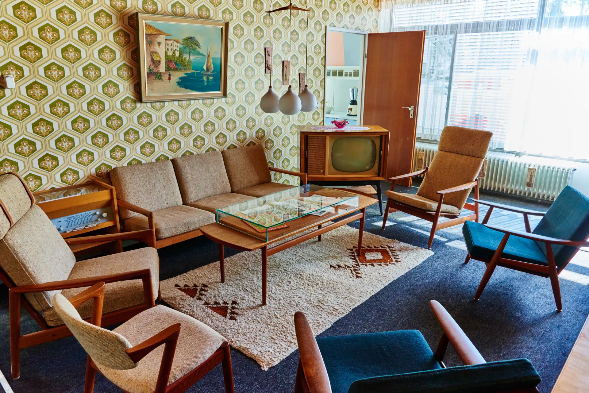 Blick in das Wohnzimmer des Quelle-Hauses mit Sitzgruppe und Fernseher