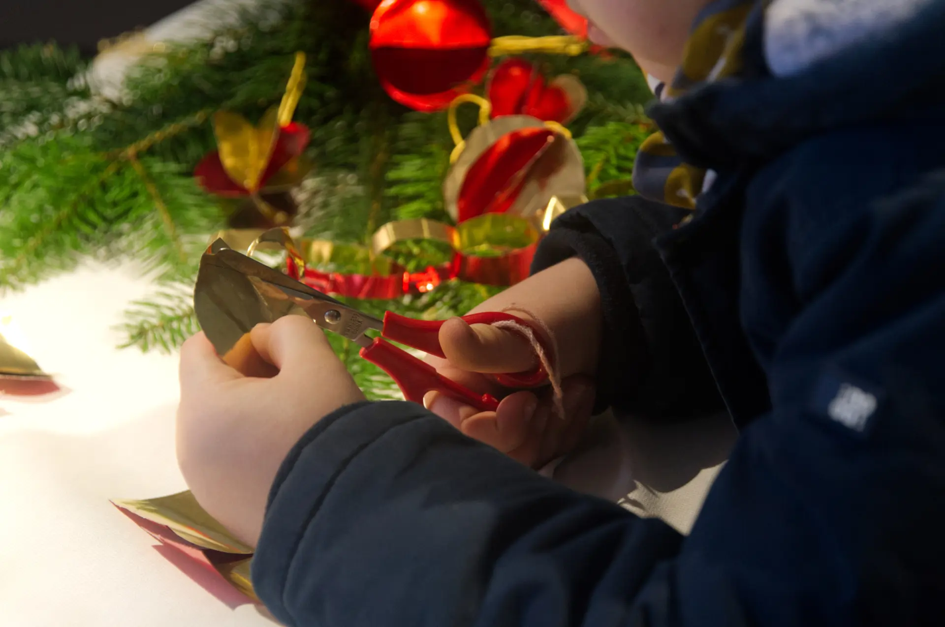 Ein Kind bastelt Weihnachtsschmuck.