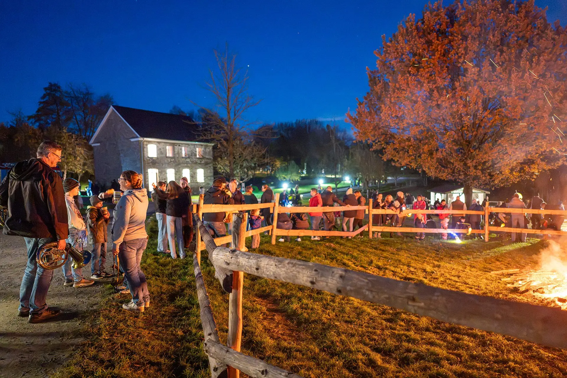 Besuchende lassen den Abend am Feuer ausklingen