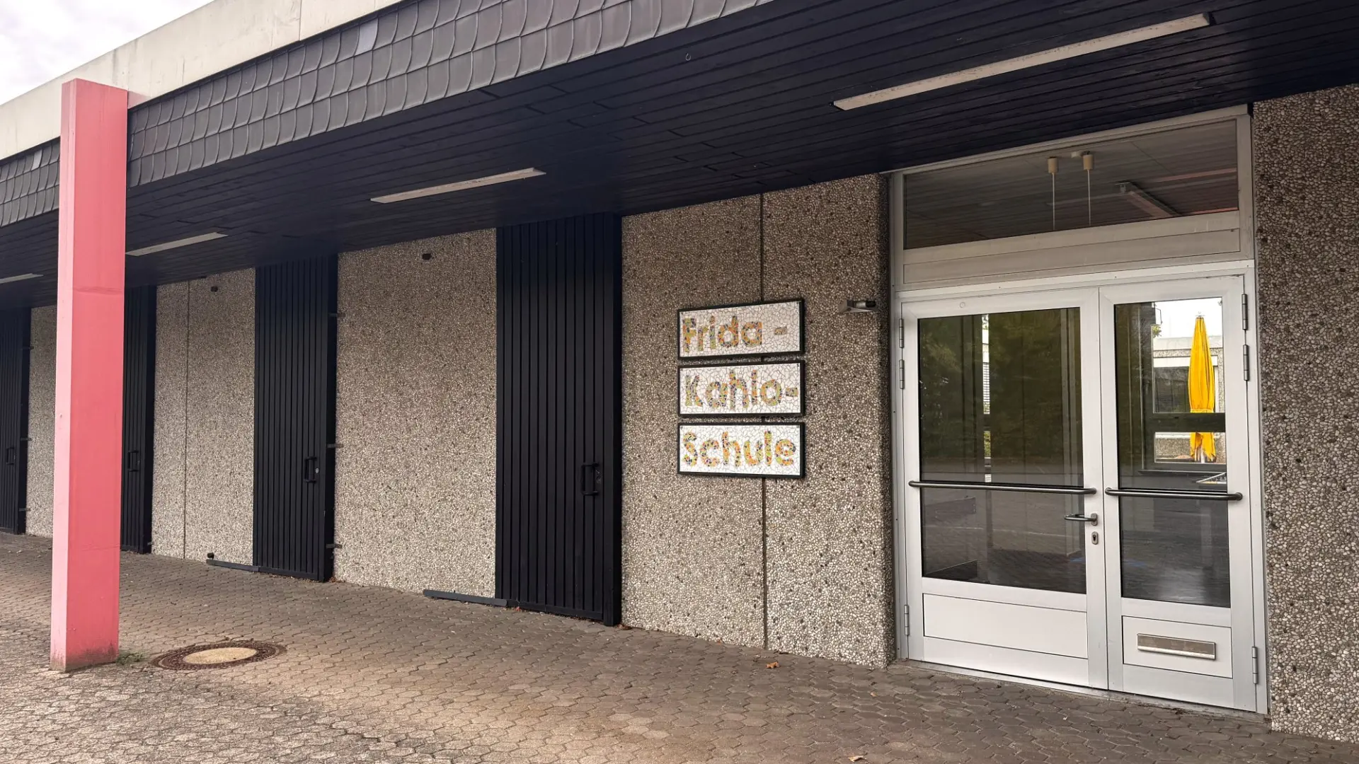 Der Schuleingang mit einem Schild 'Frida-Kahlo-Schule' in großen Buchstaben