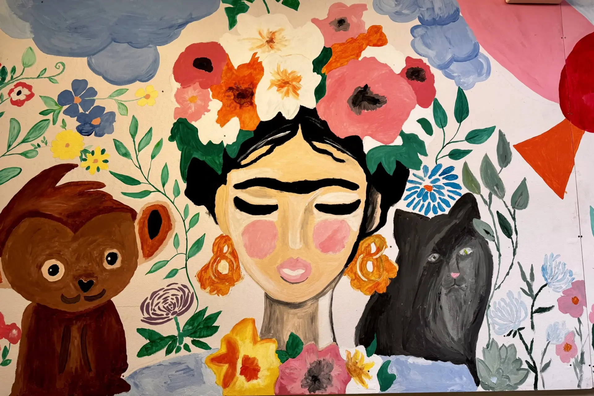 Gemälde von Frida Kahlo mit ihren Tieren und vielen Blumen an der Flurwand der Schule