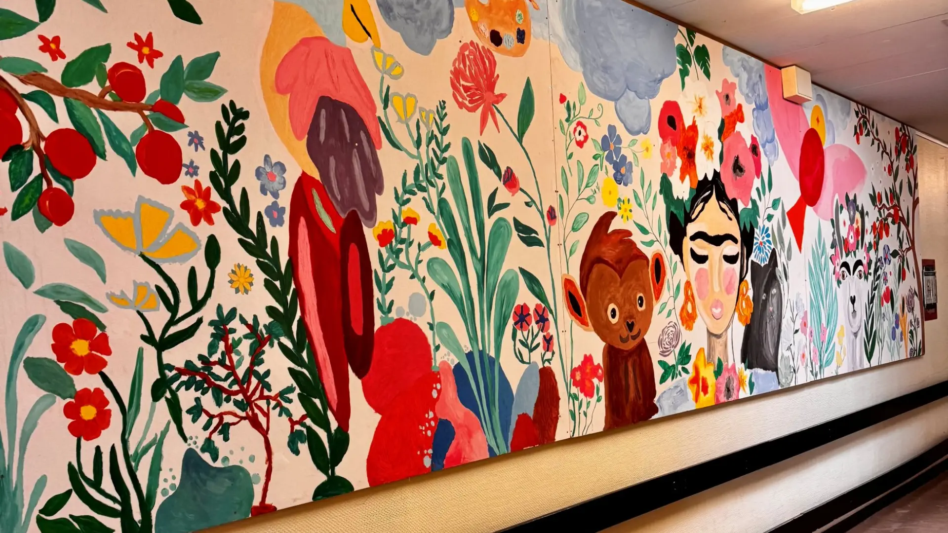 Schulgang mit einem langen, farbenfrohen Gemälde mit Blumen, Tieren und Frida Kahlo