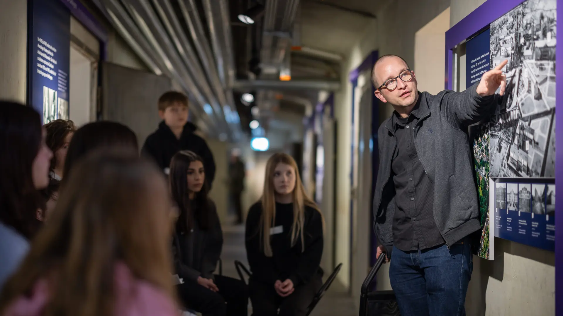 Foto von Mitarbeiter vor Schüler*innen in der Gedenkstätte