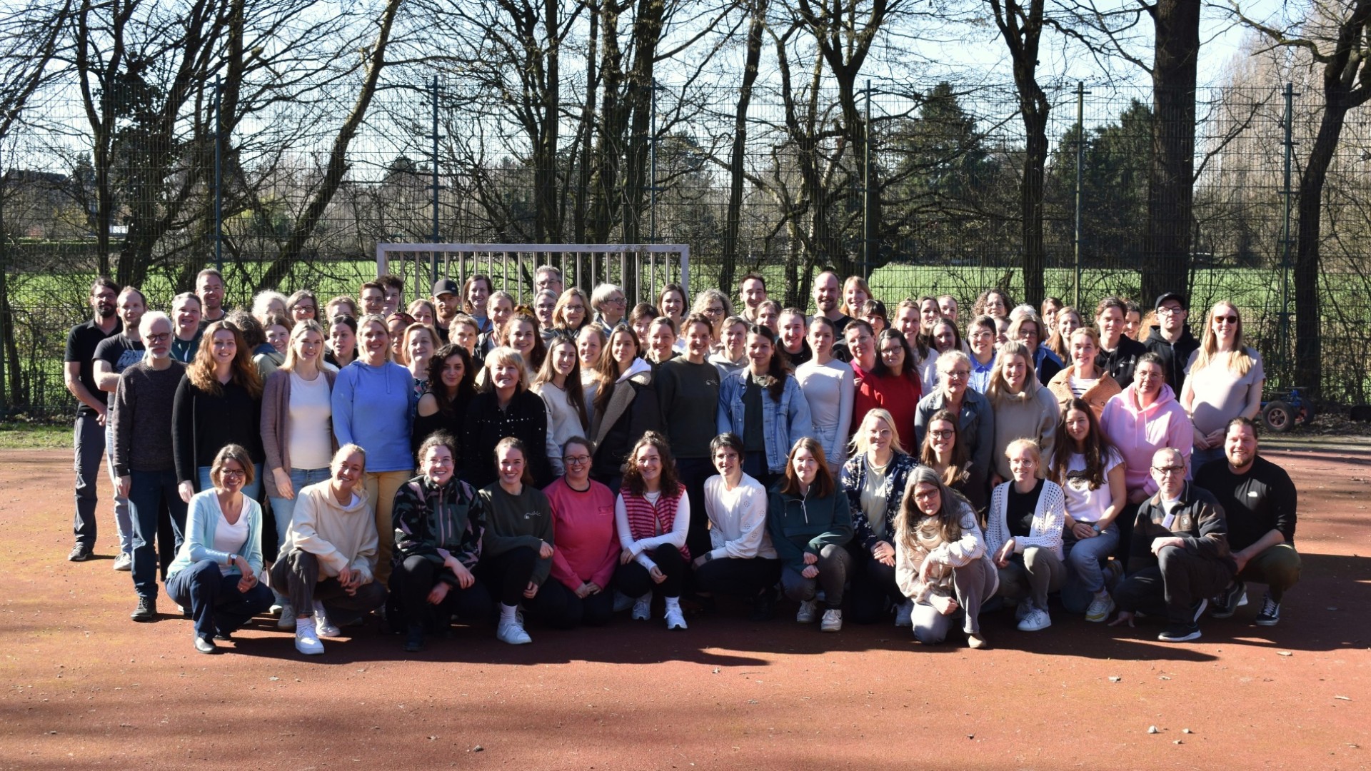 Gruppenfoto des 100 Personen zählenden Kollegiums der LVR-Gerd-Jansen-Schule auf dem Sportplatz