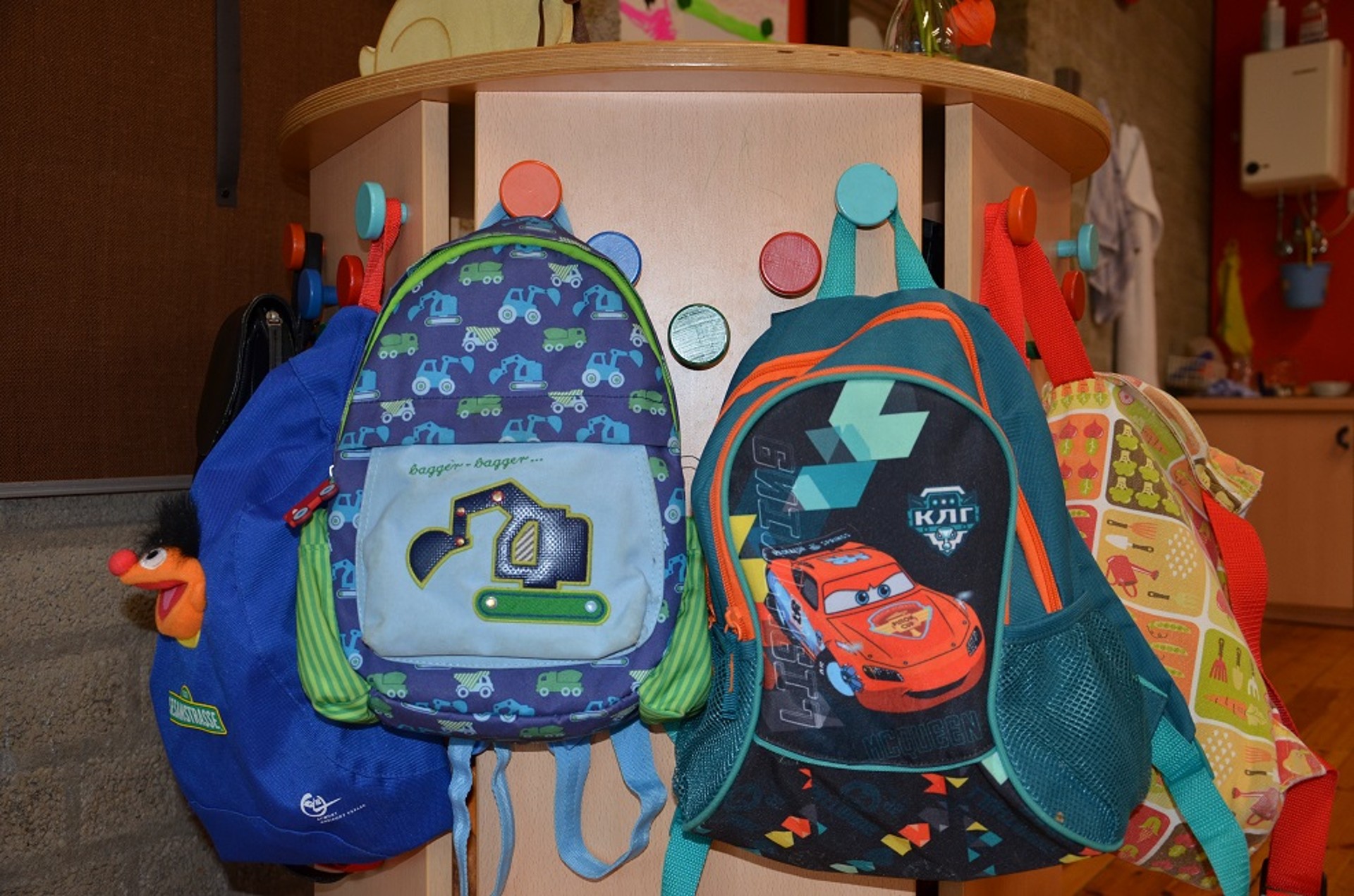 Bunte Kinderrucksäcke Rucksäcke hängen an einer bunten Garderobe.