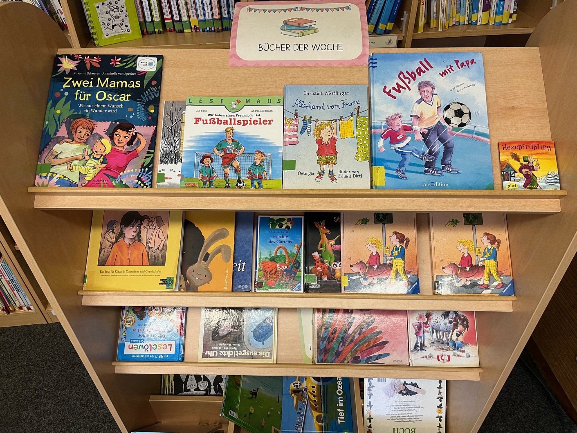 Ein kleineres Bücherregal von oben, auf dem einzelne Kinderbücher präsentiert werden