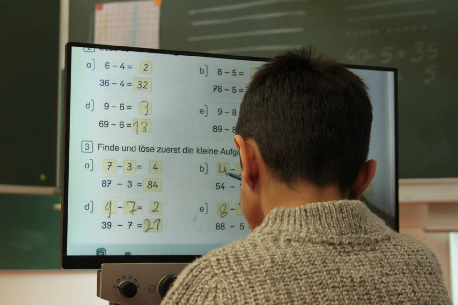 PC-Monitor: Kind löst Matheaufgaben am Computer