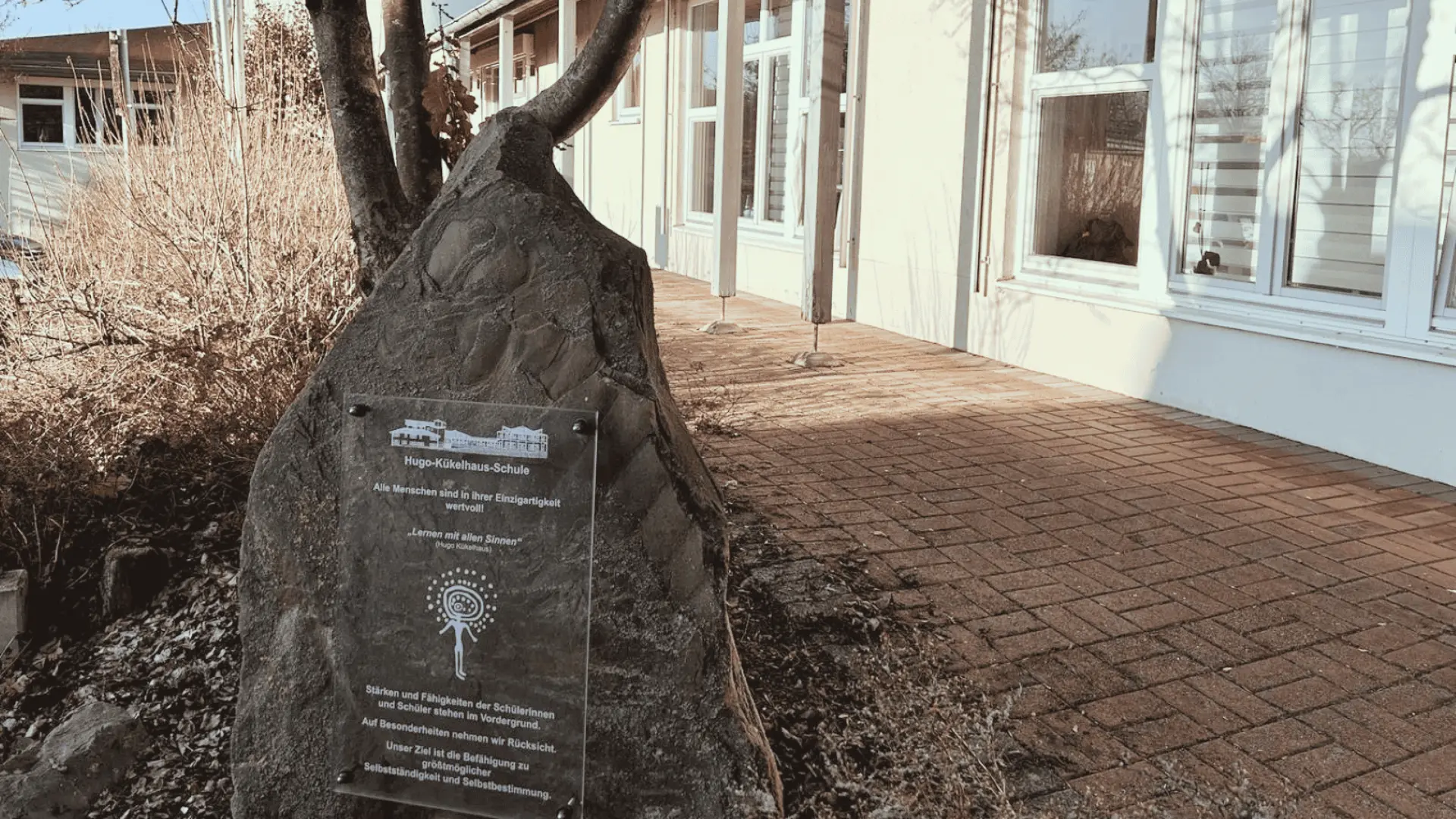 Stein mit Schild der LVR-Hugo-Kükelhaus-Schule vor dem Schulgebäude