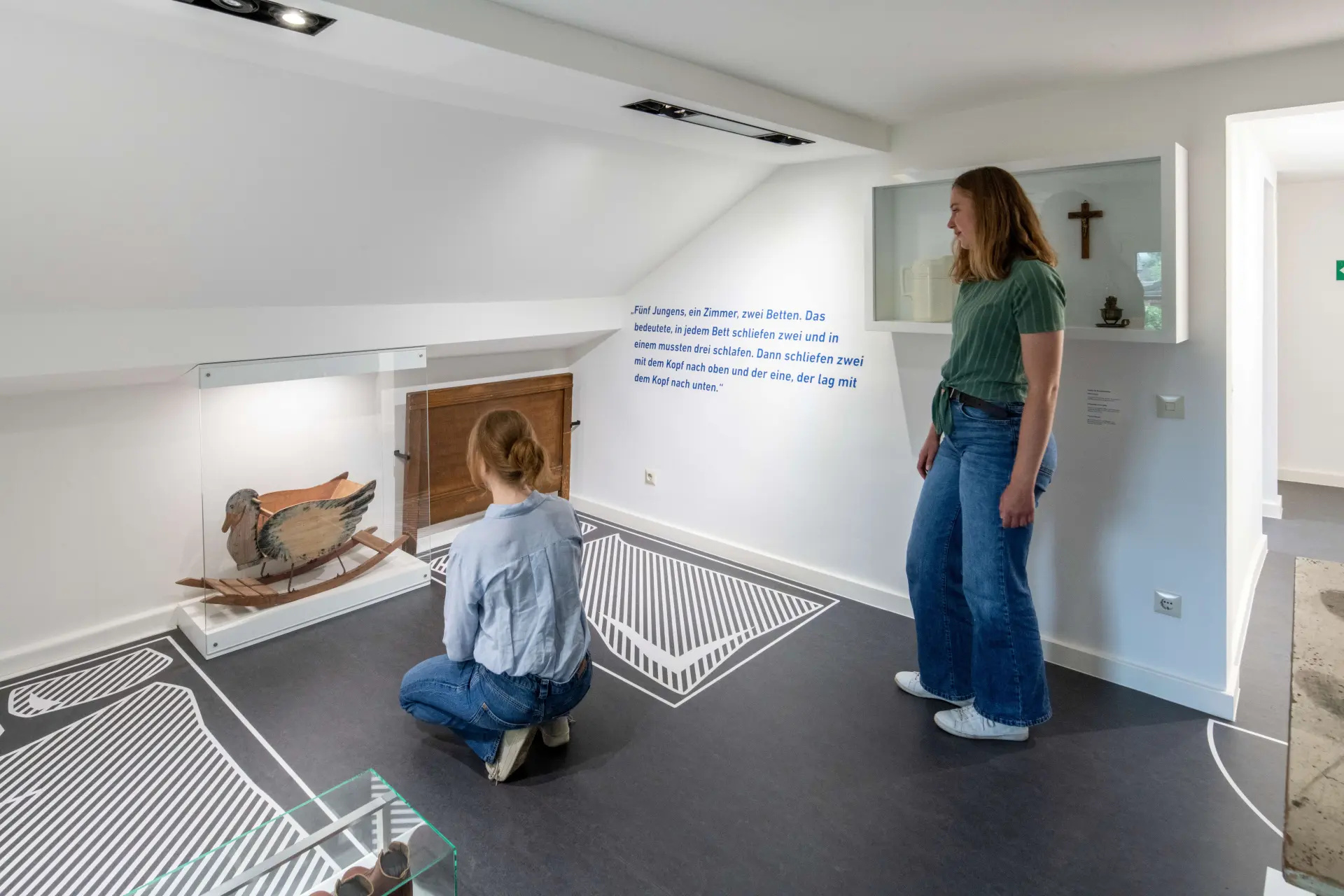Zwei Frauen schauen sich Exponate in einem Ausstellungsraum an