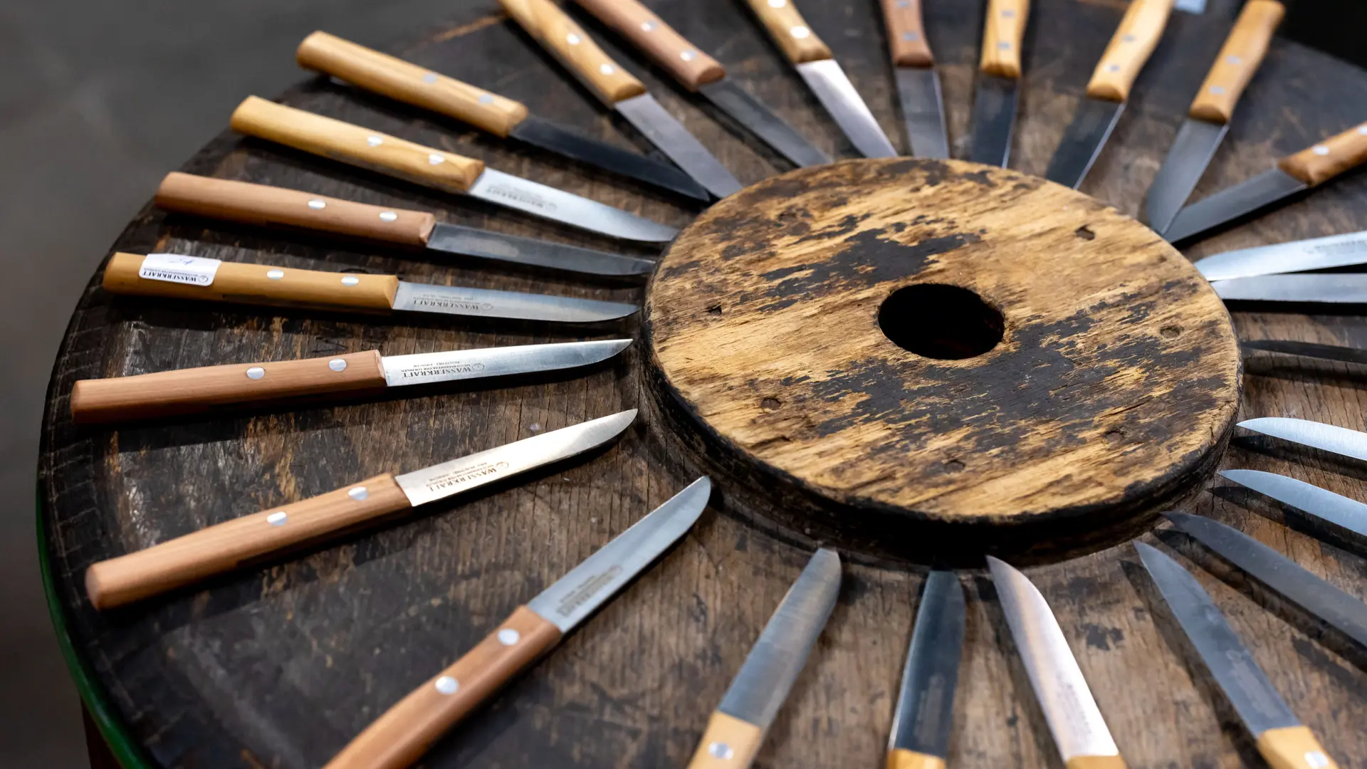 Kleine Messer mit Holzgriff liegen in einem Kreis angeordnet.