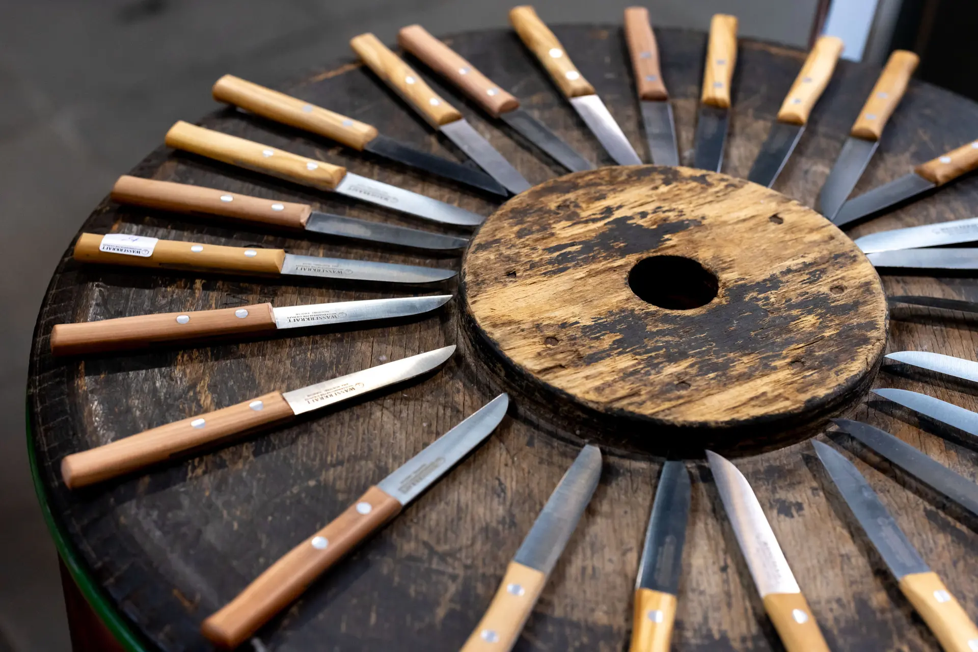 Kleine Messer mit Holzgriff liegen in einem Kreis angeordnet.