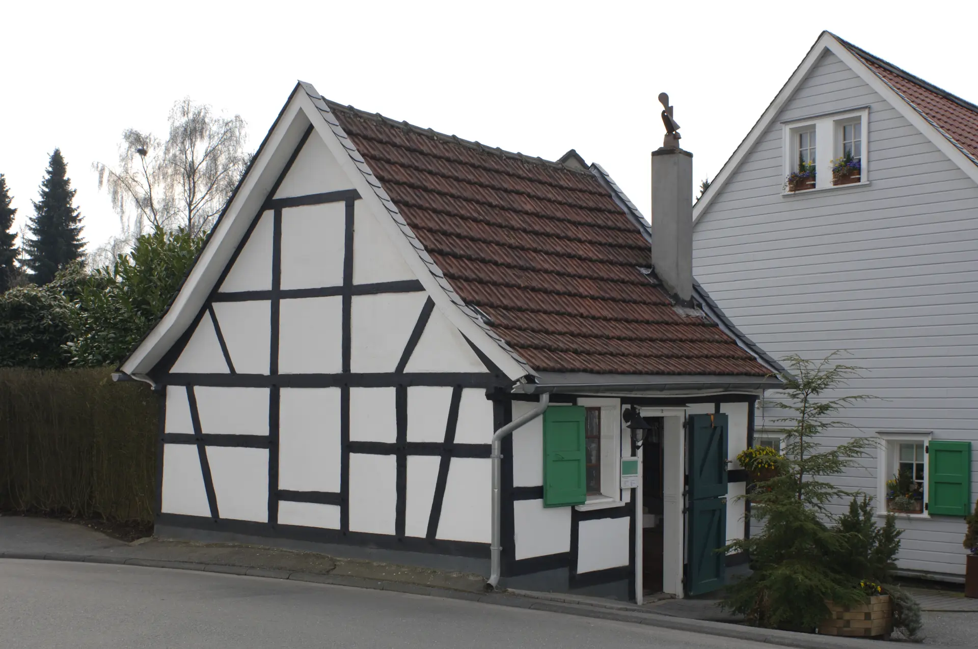 Ein kleines Fachwerkhäuschen mit grünen Fensterläden.
