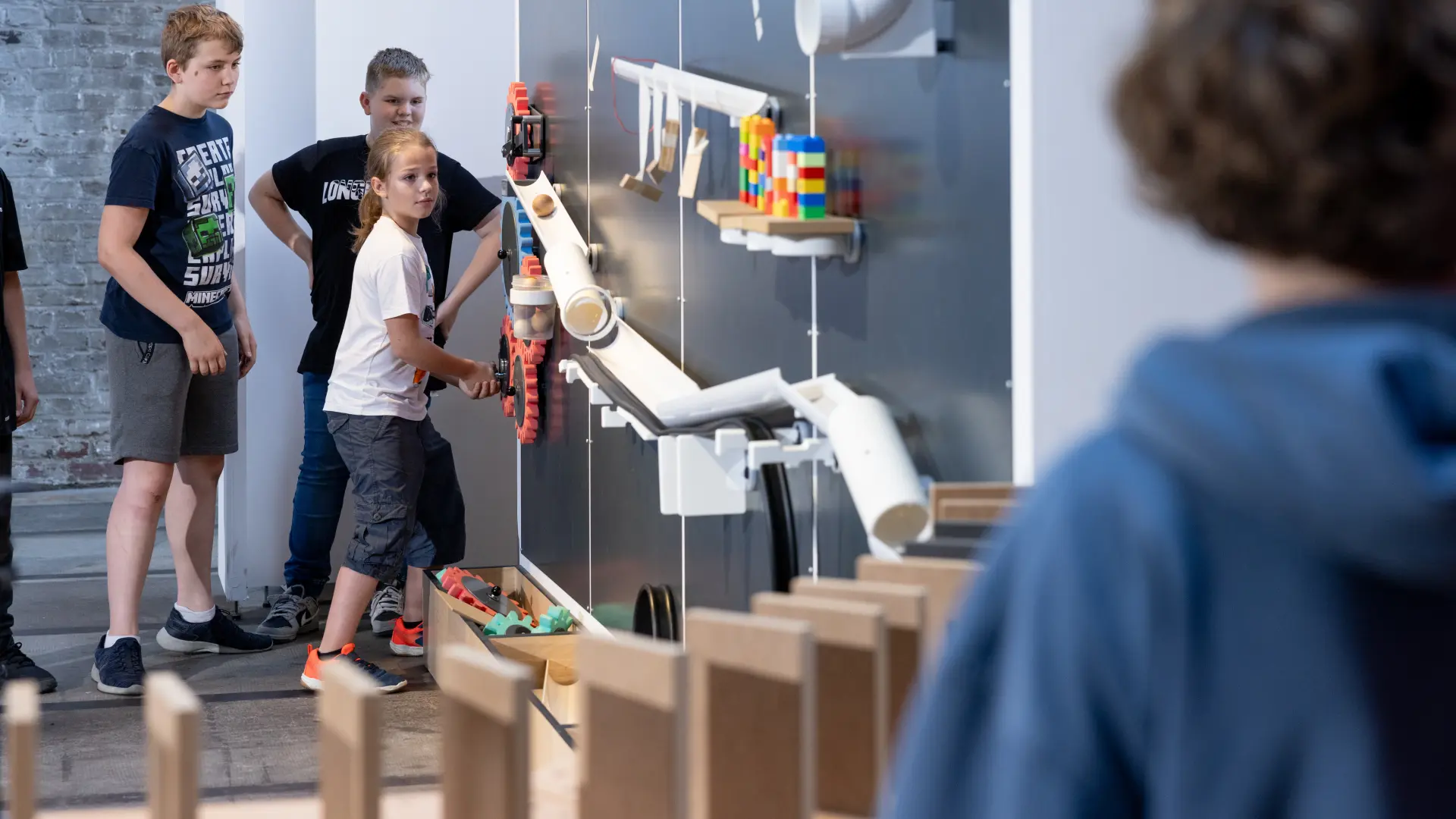 Kinder bauen entlang einer Wand eine Kettenreaktion auf.