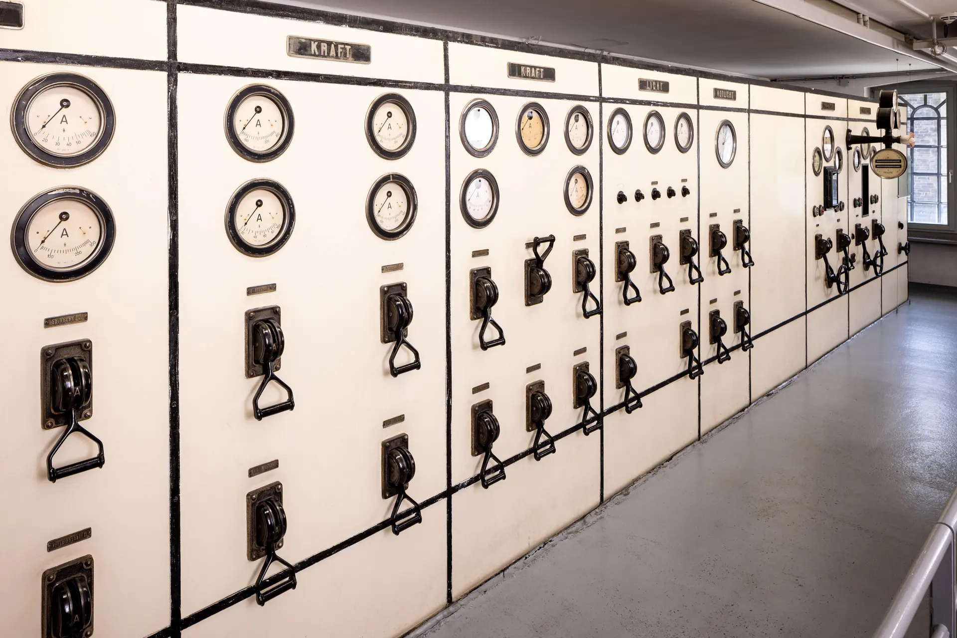 Eine Wand mit vielen Hebeln, Knöpfen und Messgeräten.
