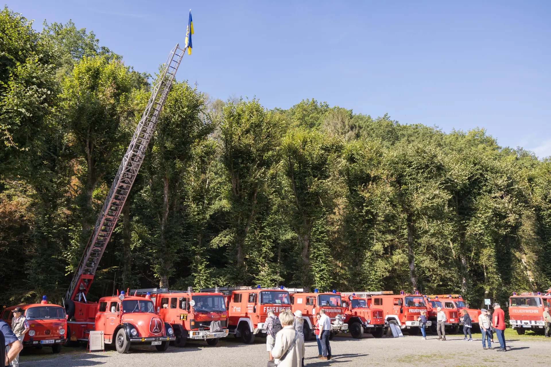 Viele historische Feuerwehrautos auf einem Platz.