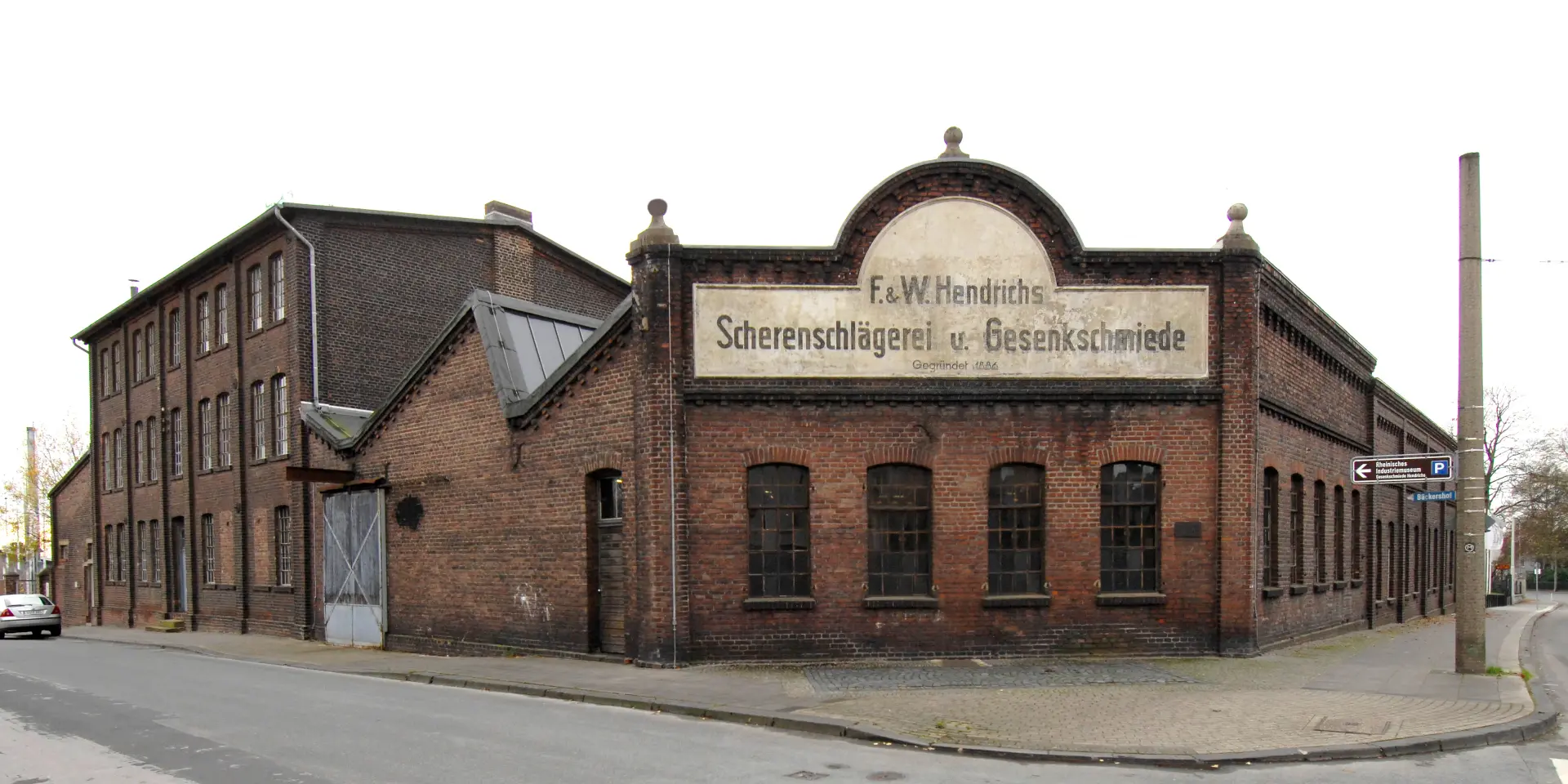 Ein Backsteingebäude mit einem Schild, auf dem Gesenkschmiede Hendrichs steht.