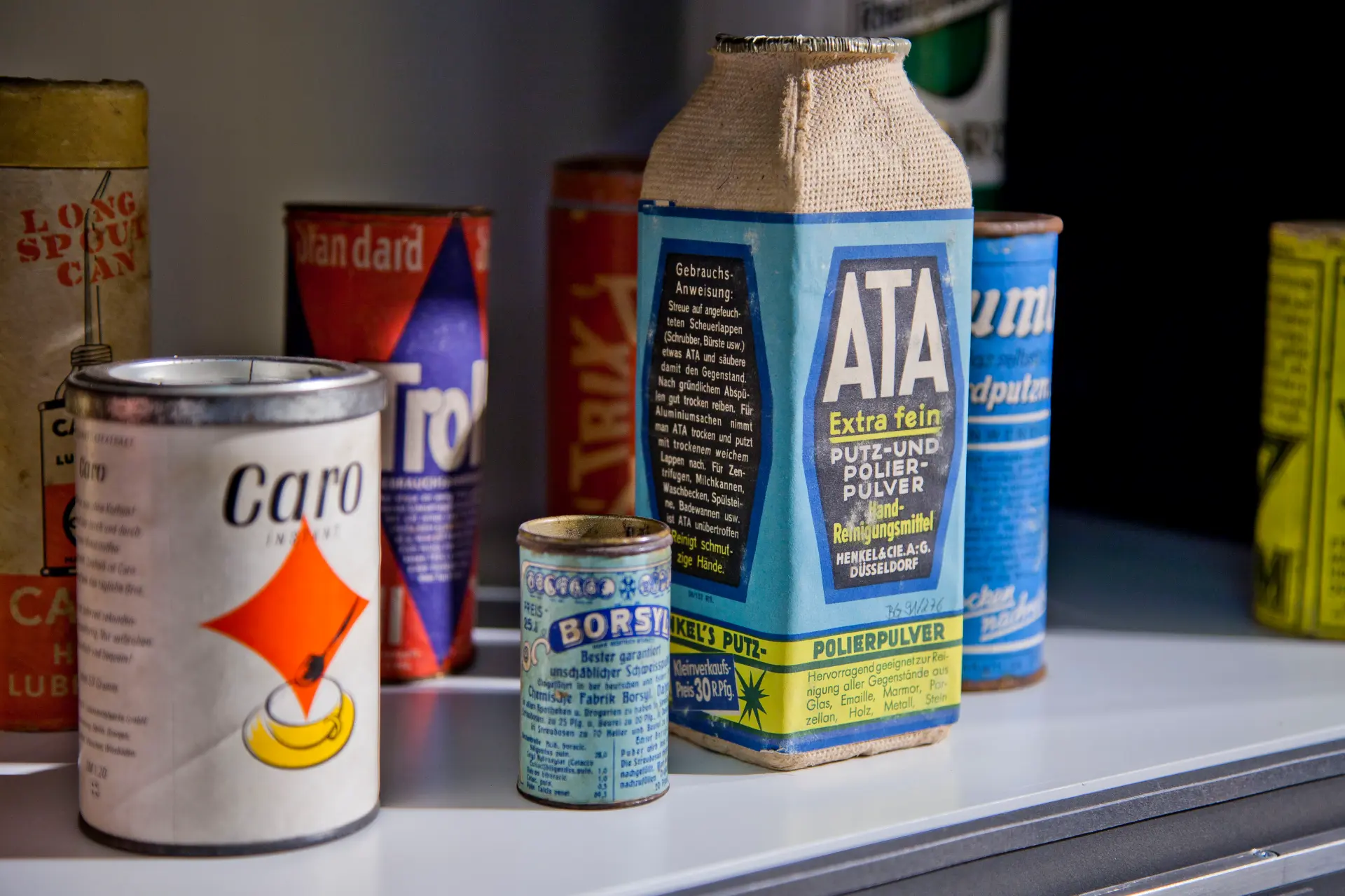 Verschiedene historische Verpackungen aus Papier in einer Vitrine