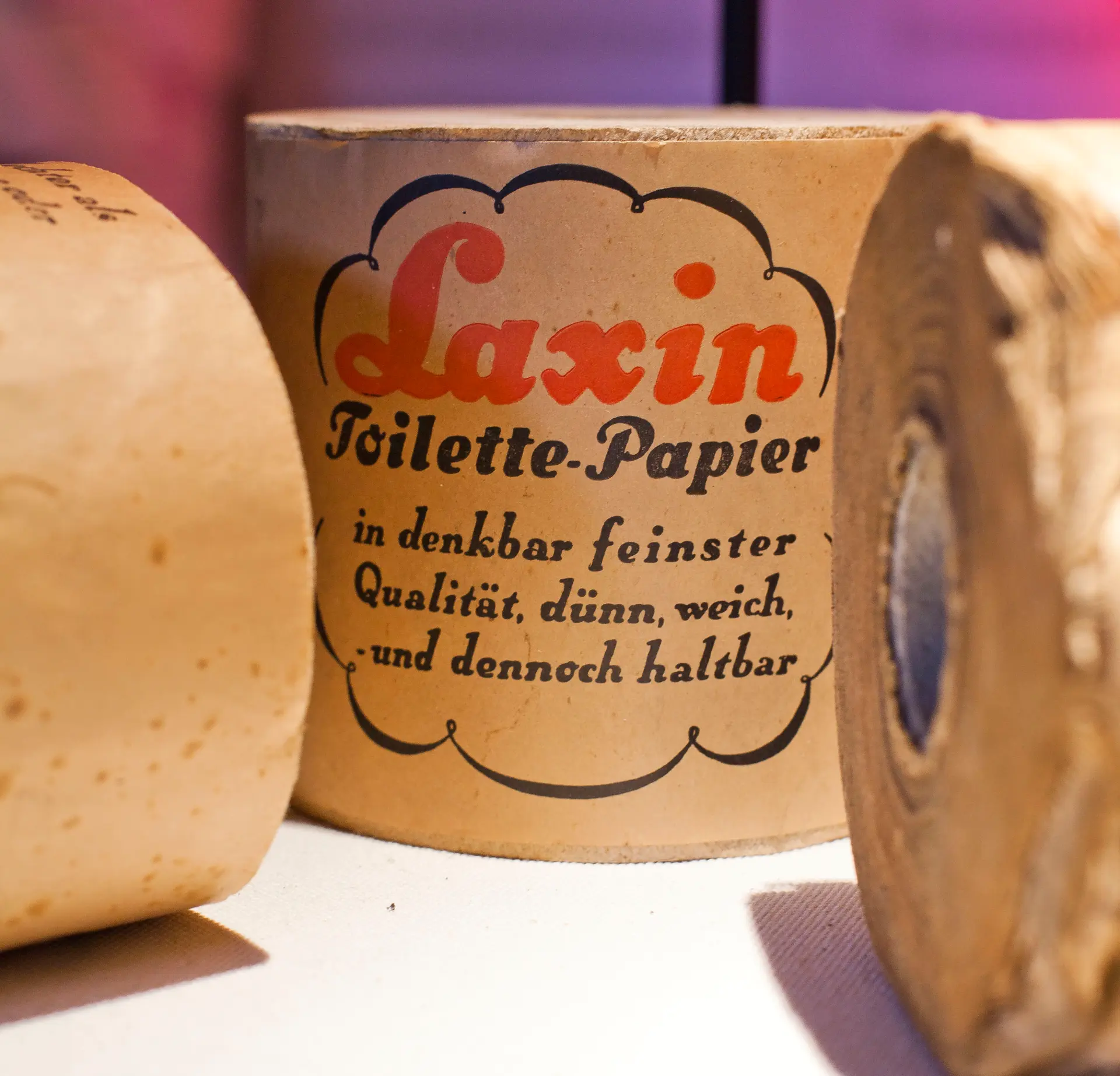 Verschiedene historische Verpackungen aus Papier in einer Vitrine
