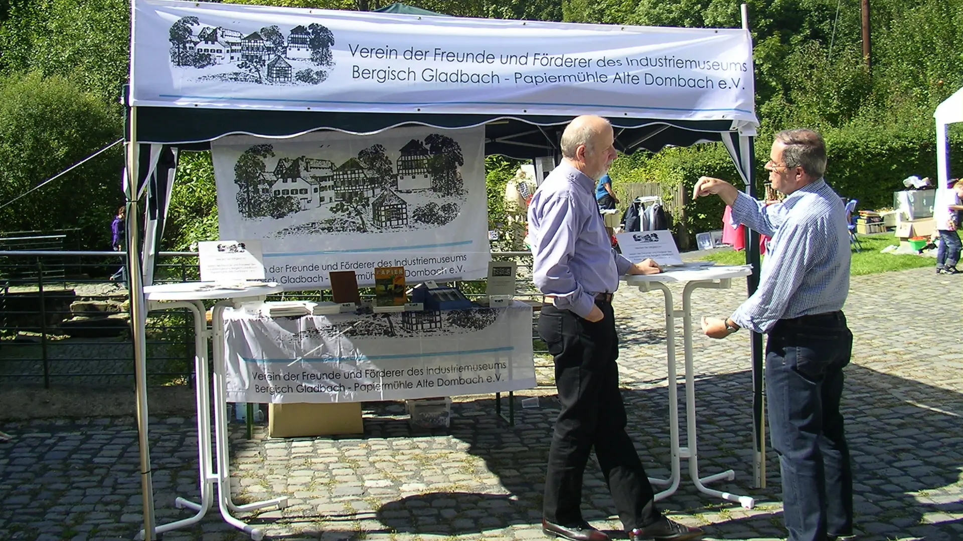 Männer an einem Infostand im Freien