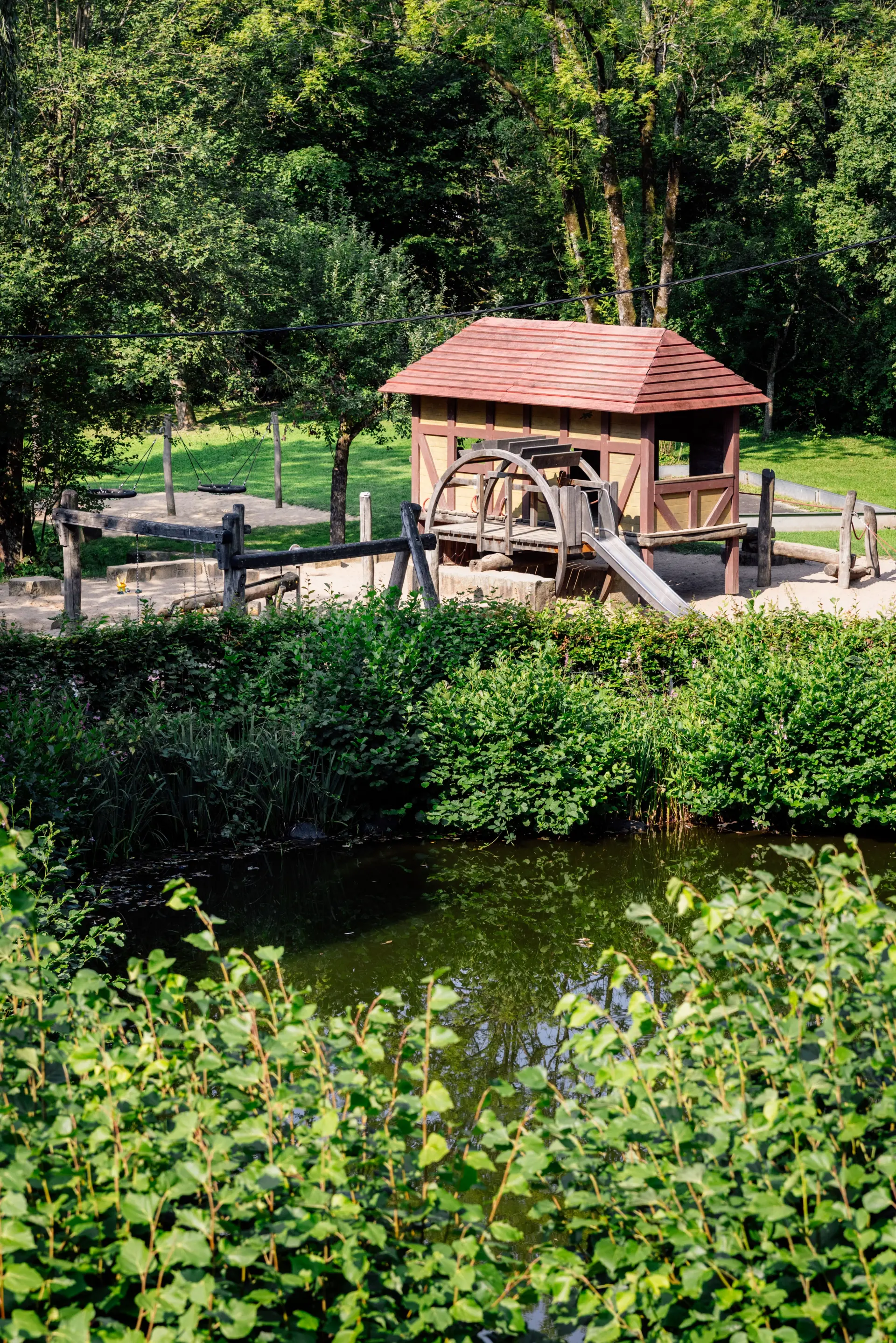 Grüne Hecke, dahinter ein Spielplatz