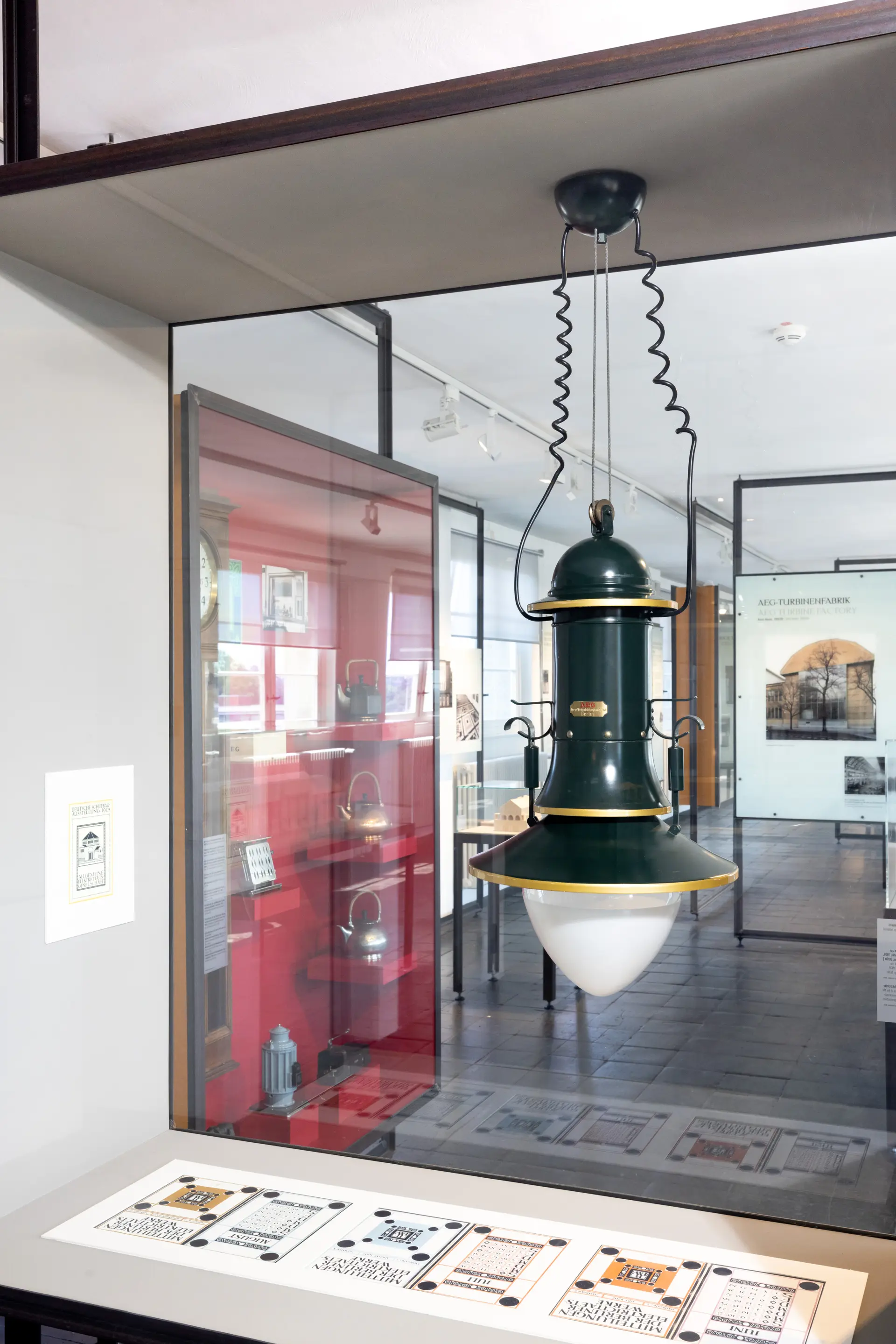 Rote Wand mit verschiedenen Exponaten in einer Ausstellung