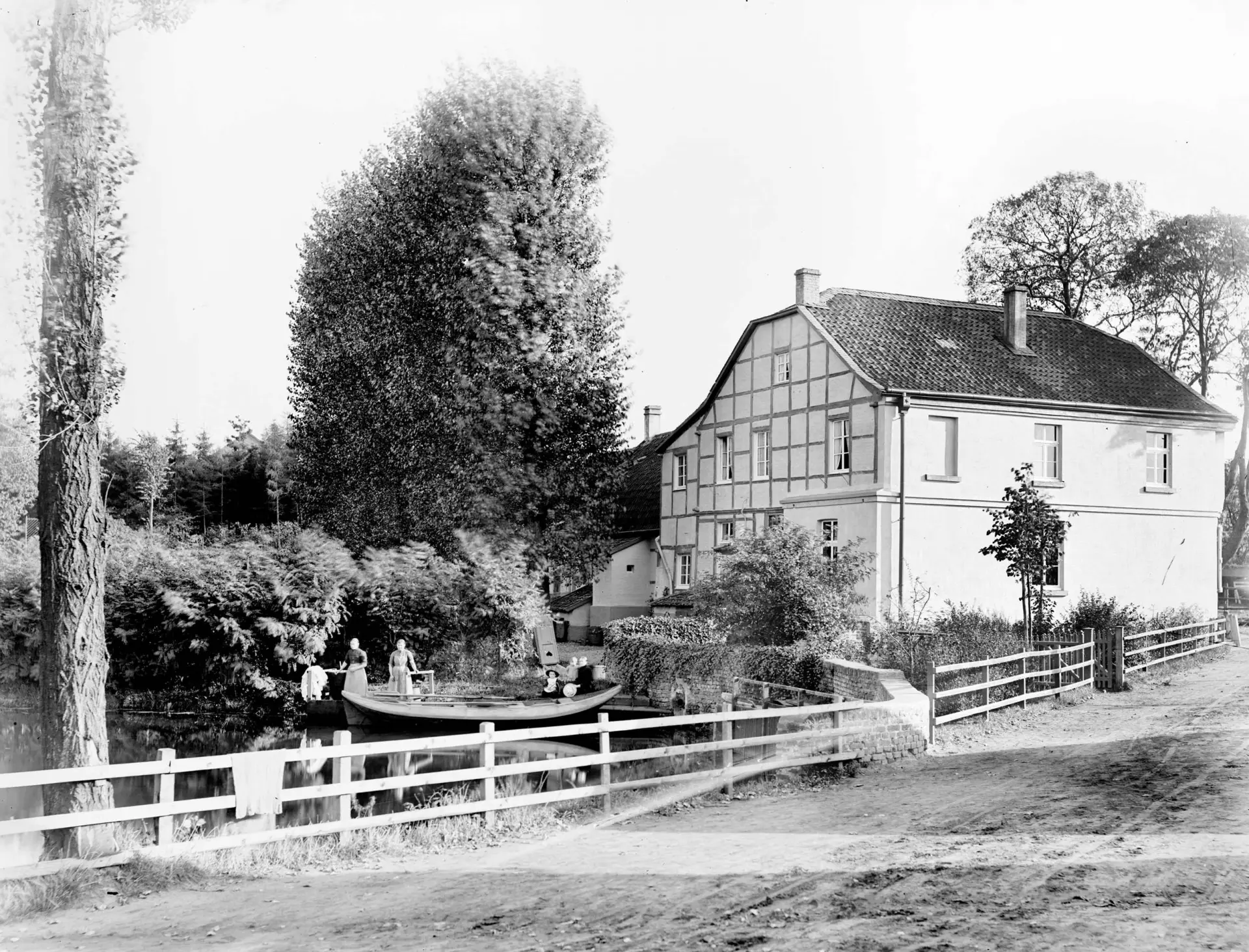 Historisches Schwarzweiß-Foto eines Gebäudes neben einem Teich