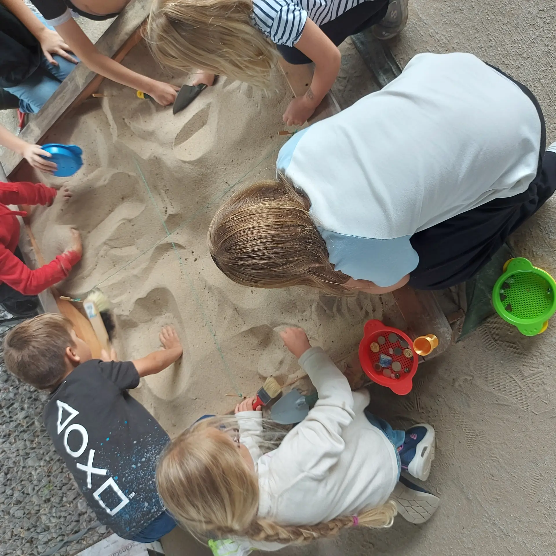 Mehrere Kinder buddeln im Sand
