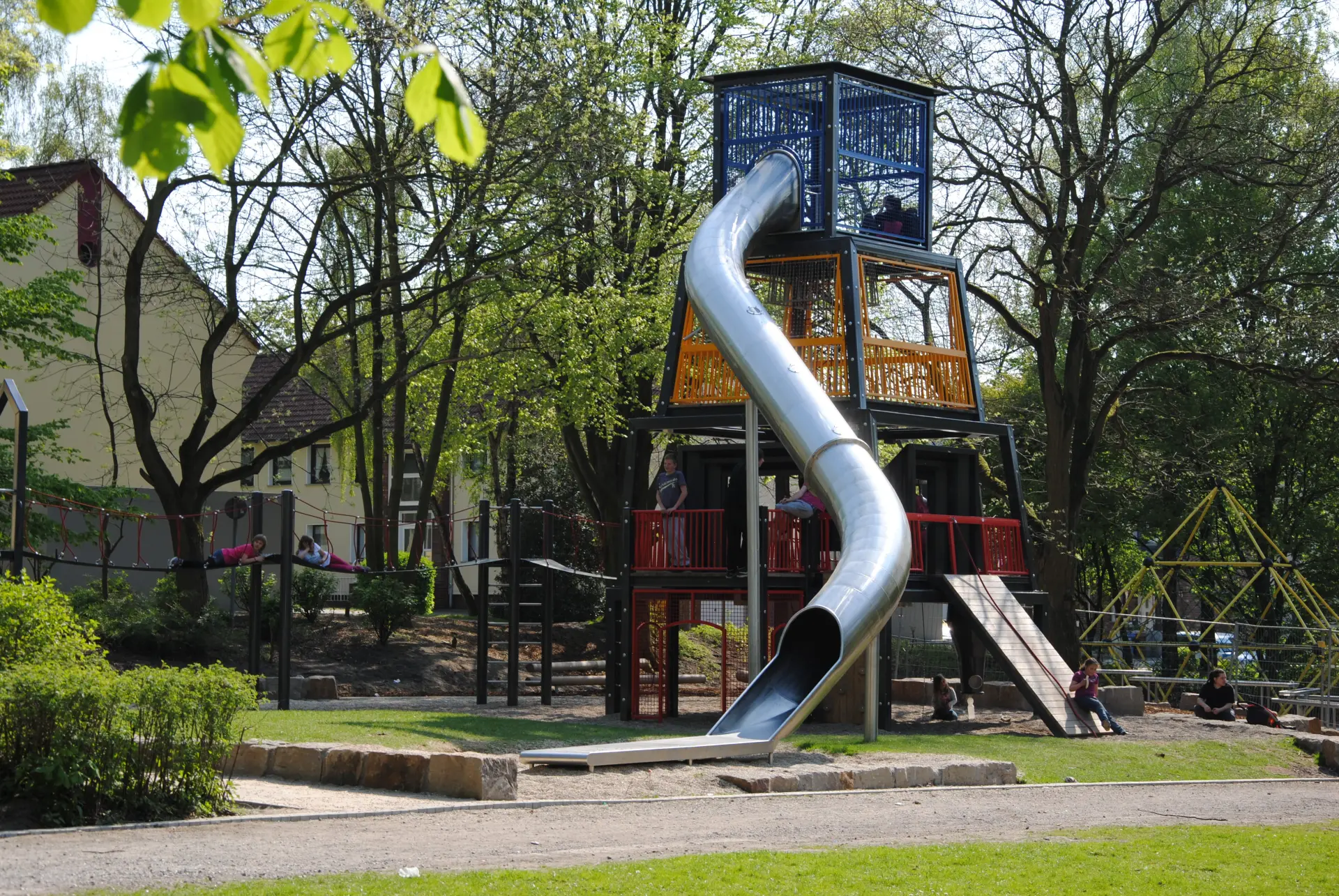 Ein großer Spielturm mit Klettergerüsten und Röhrenrutsche