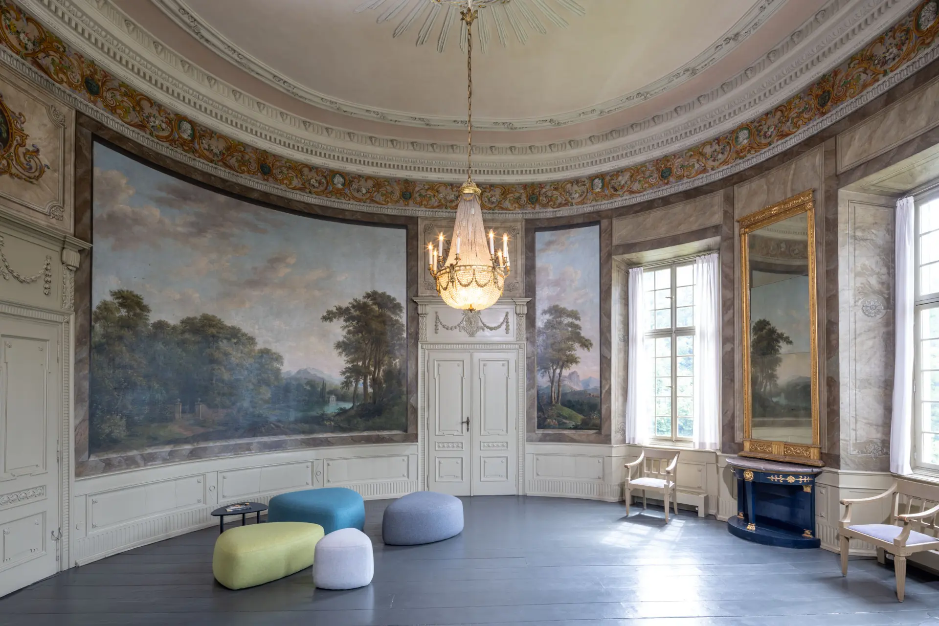 Blick in einen kreisrunden Saal mit Landschaftsmalereien