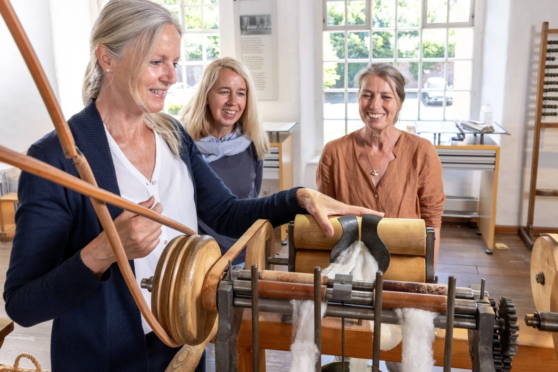 Drei Frauen an einer Textilmaschine
