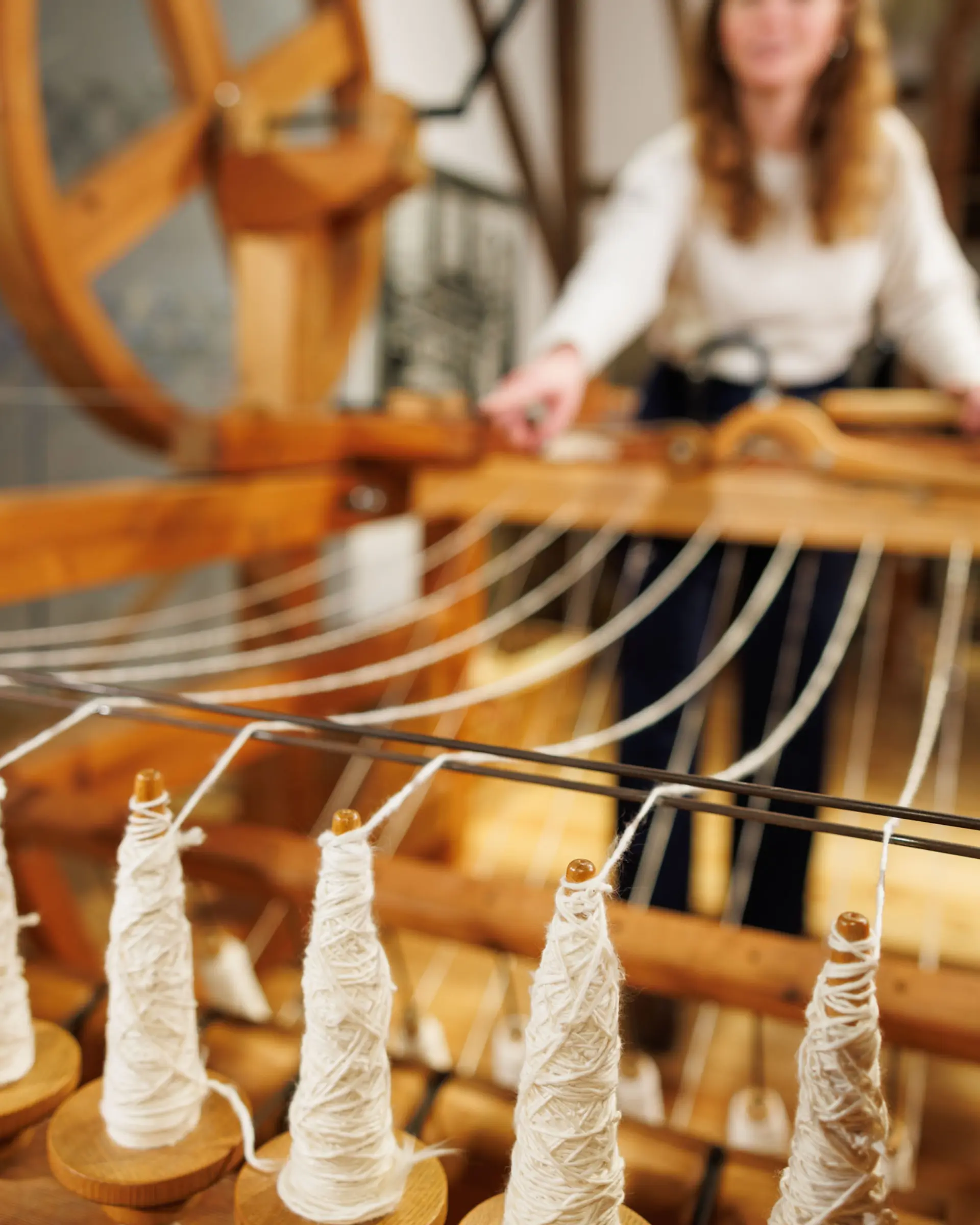 Eine Frau an einer Handspinnmaschine