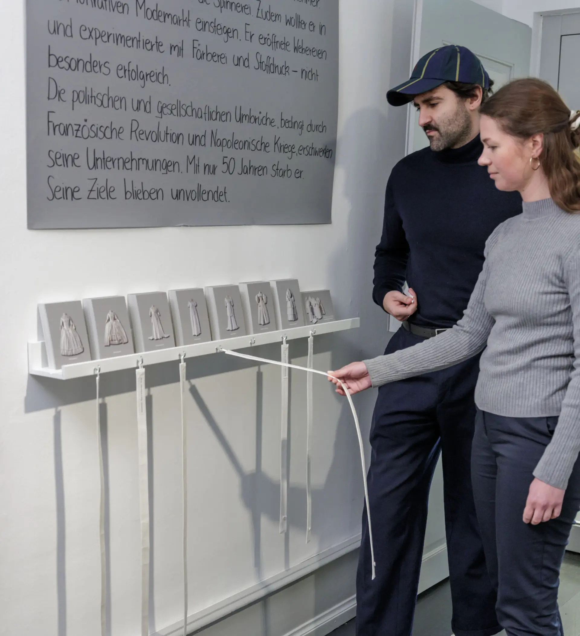 Eine Frau hält bei einem Mann ein Maßband um die Taille