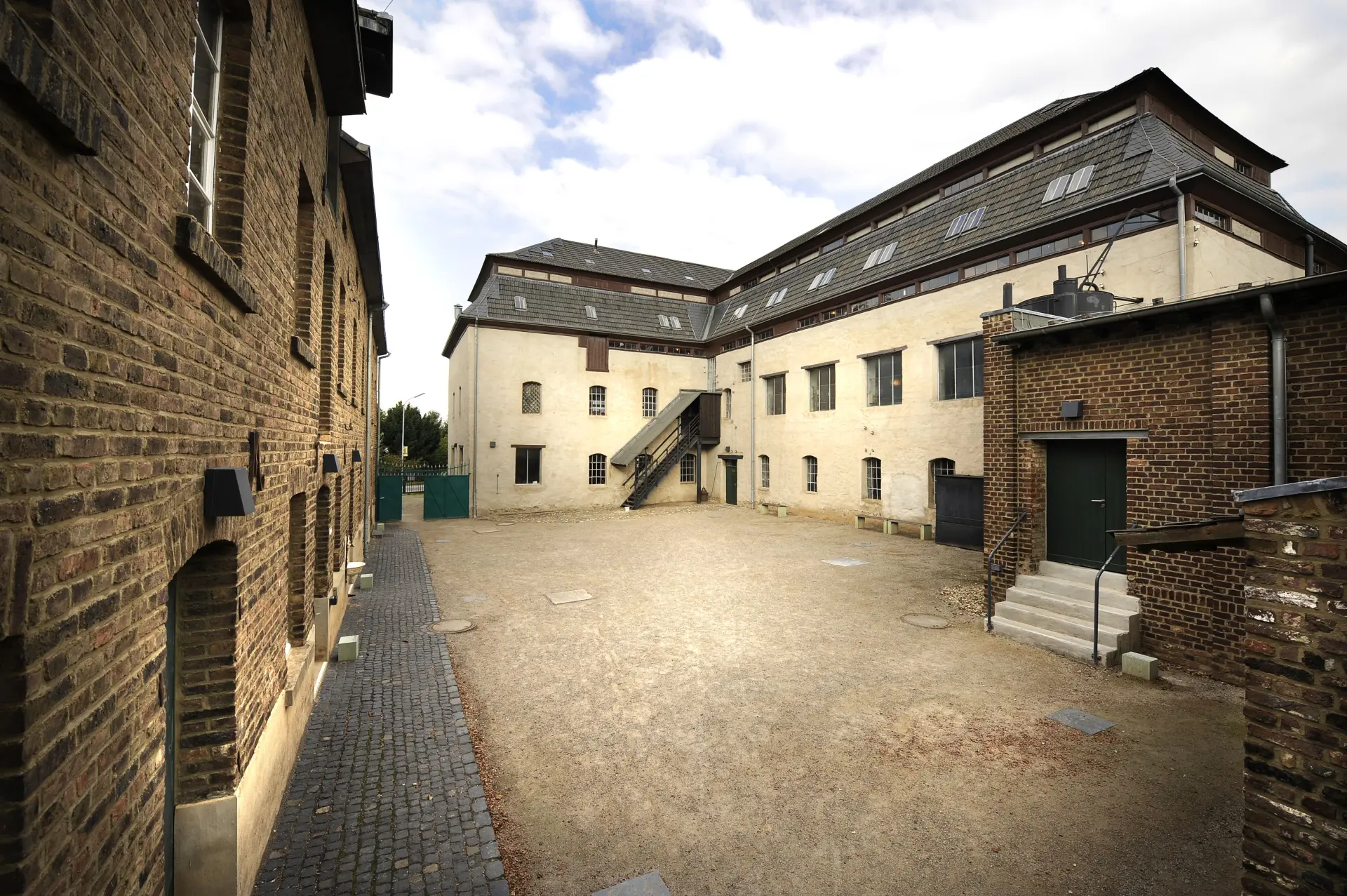 Blick in einen Fabrikhof mit umliegenden Gebäuden