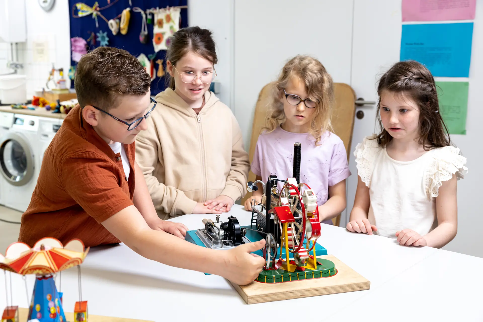 Vier Kinder testen das Modell einer kleinen Dampfmaschine.