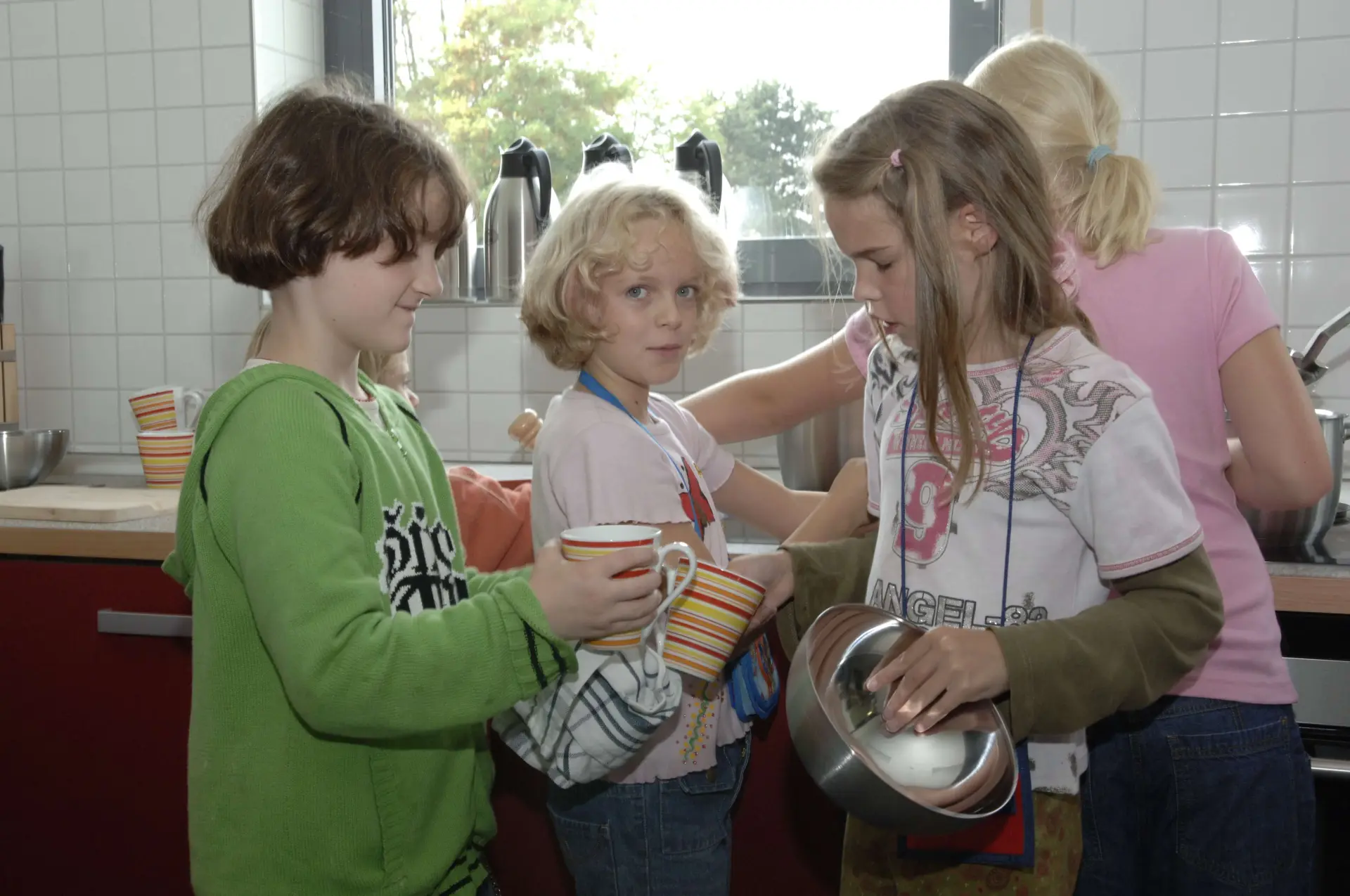 Vier Kinder spülen und trocknen Geschirr ab.