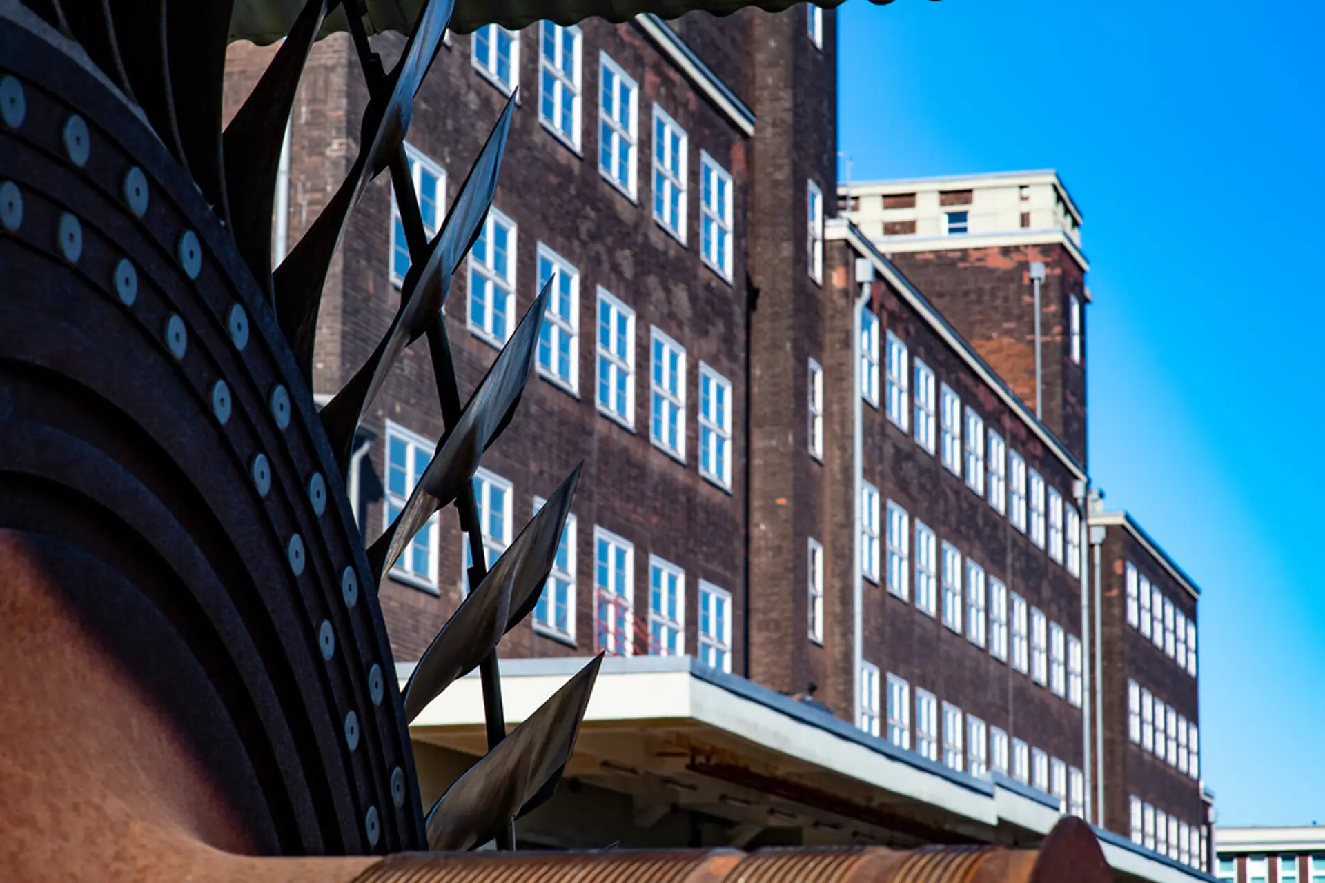 Außenansicht eines großen Gebäudes mit vielen Fenstern vor blauem Himmel