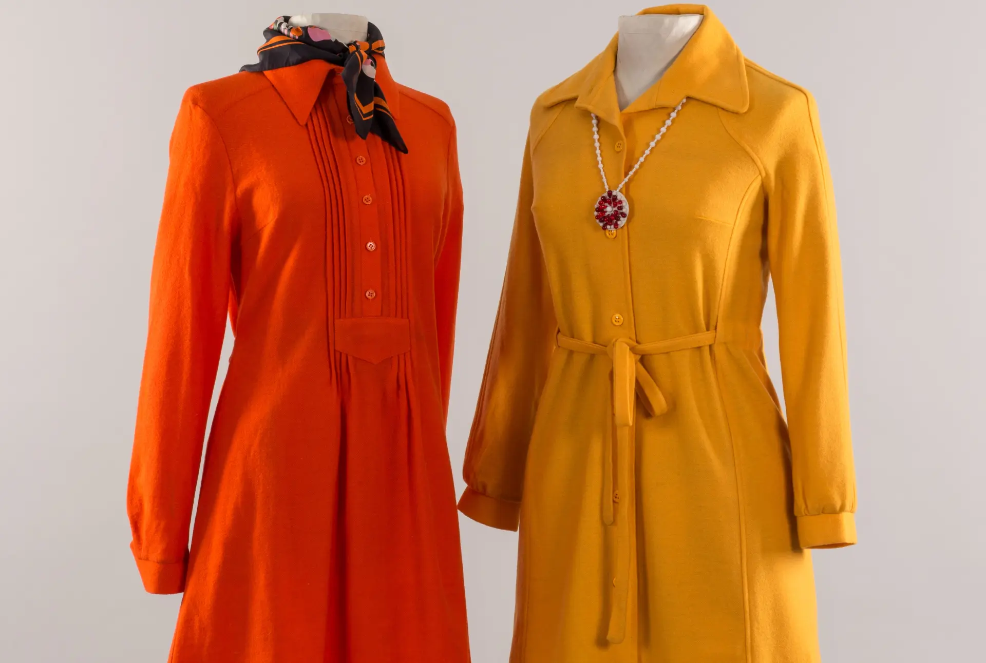 Ein oranges und ein gelbes Hemdblusenkleid an Figurinen