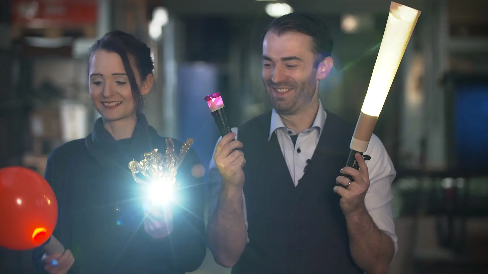 Ein Mann und eine Frau halten mit Papier umwickelte Taschenlampen.