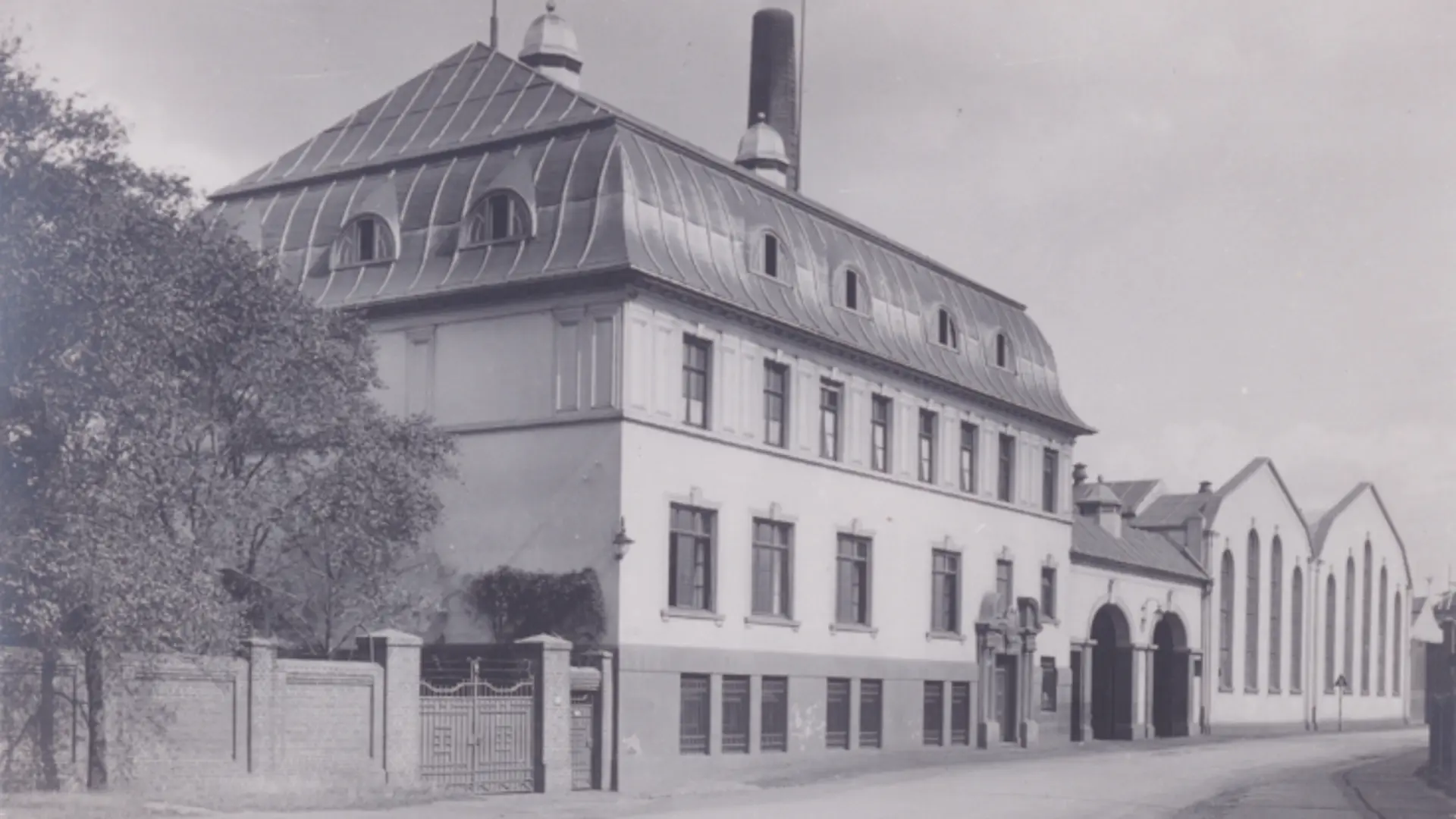 Historische schwarz-weiß Aufnahme von einem Gebäude an einer Straße neben der Zinkfabrik Altenberg.