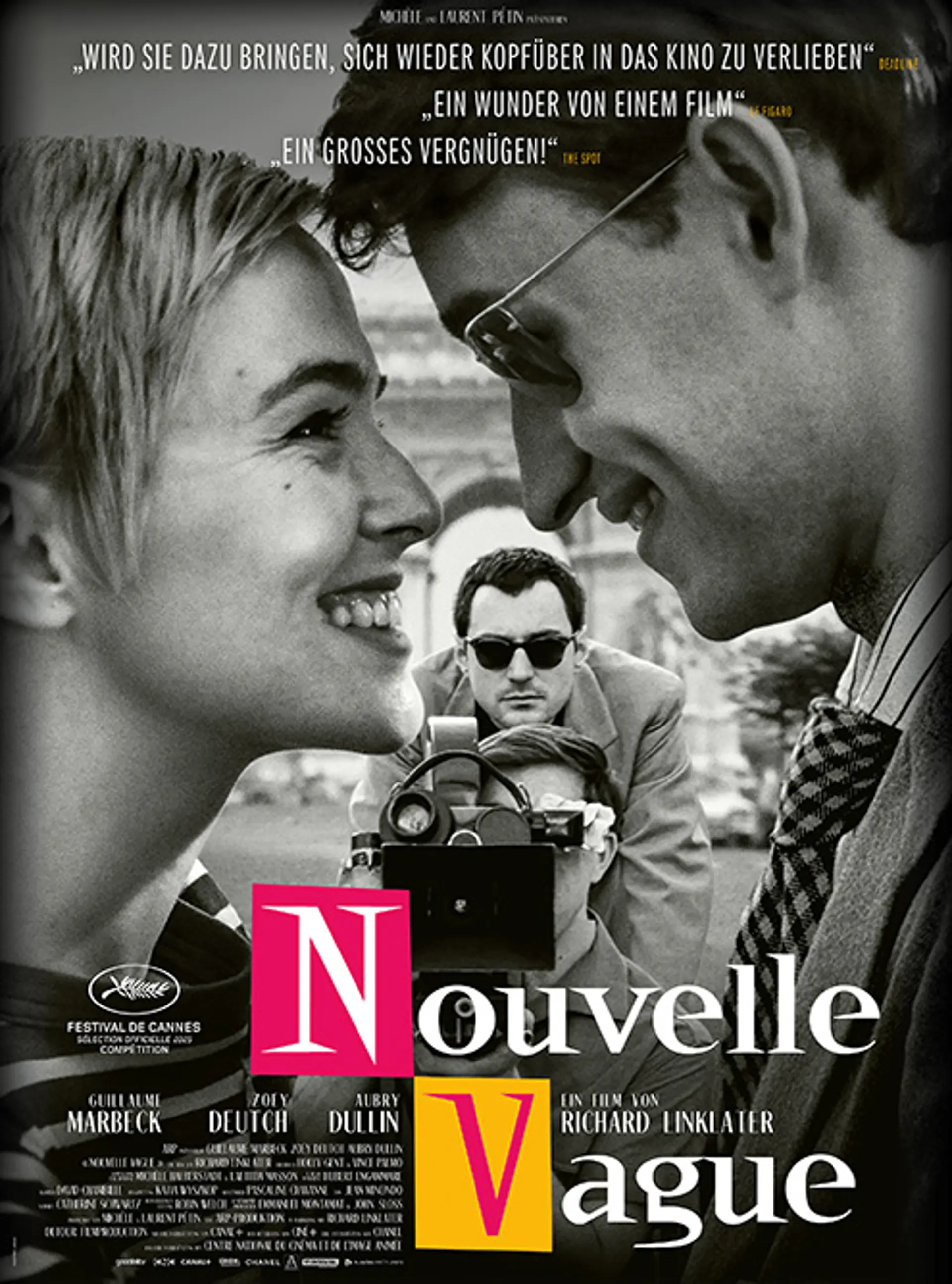 Schwarz-weiße Fotografie einer Filmdrehszene in Paris. Eine junge Frau und ein junger Mann lächeln sich gegenseitig an. In der Mitte des Bildes filmt ein Kameramann. Dahinter steht ein Mann mit dunklen Haaren und Sonnenbrille und blickt auf die Szene. Unten steht der Filmtitel „Nouvelle Vague“. 