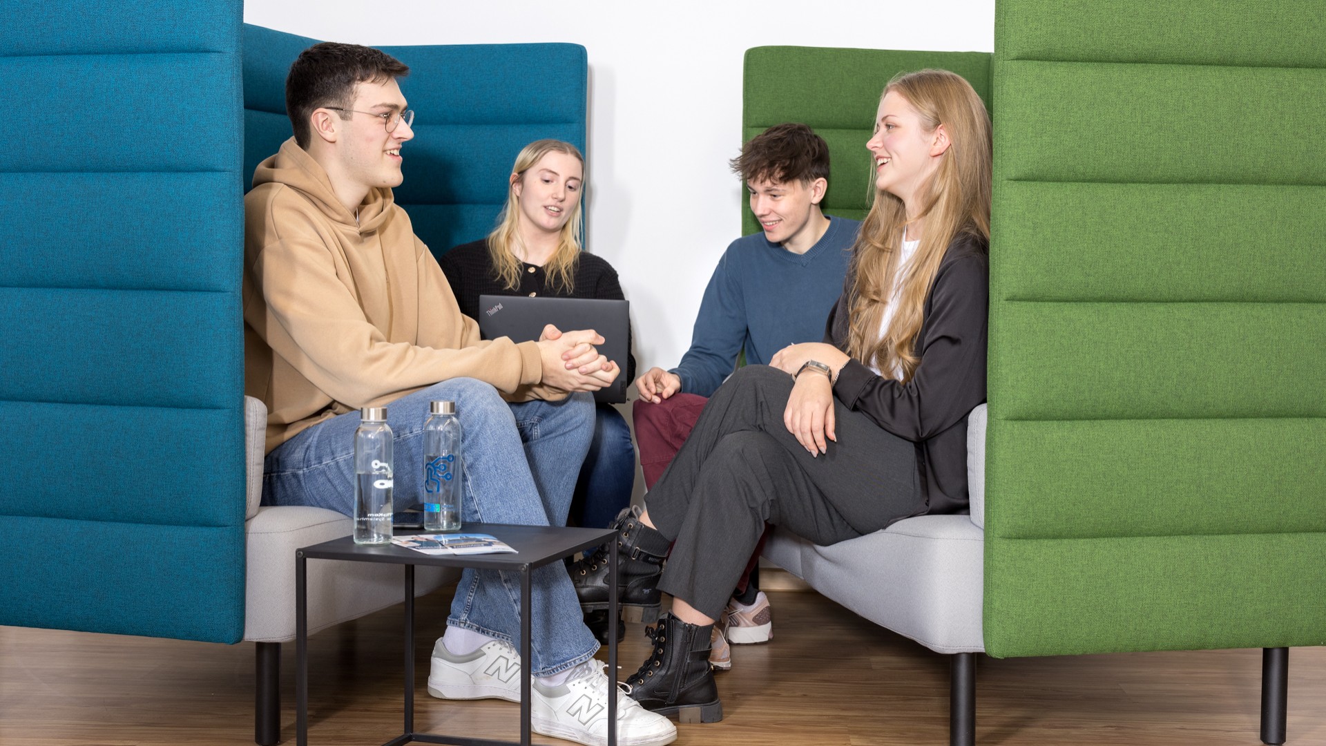 4 Nachwuchskräfte unterhalten sich in einer Sitzgruppe