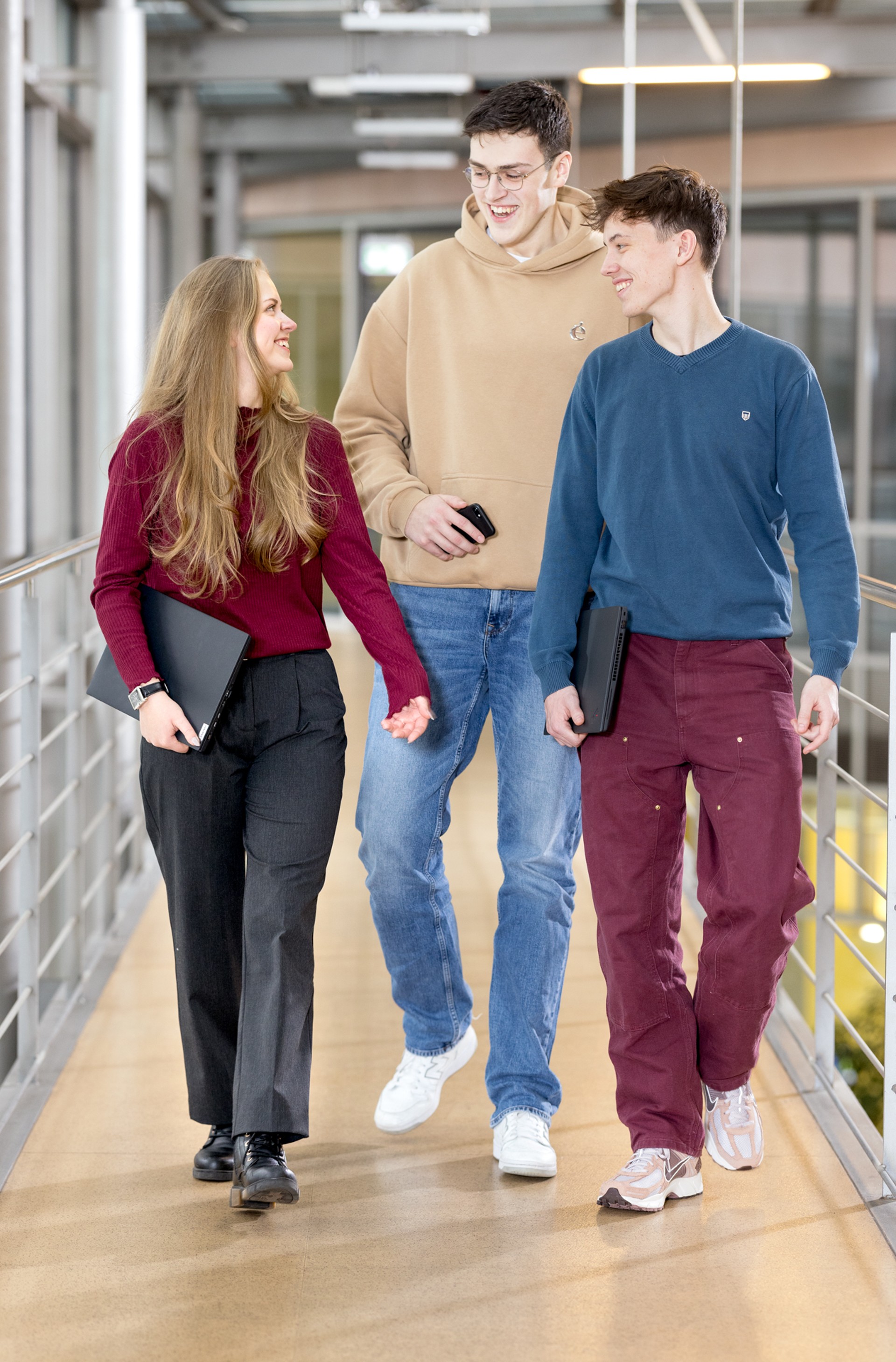 Drei Nachwuchskräfte gehen und unterhalten sich