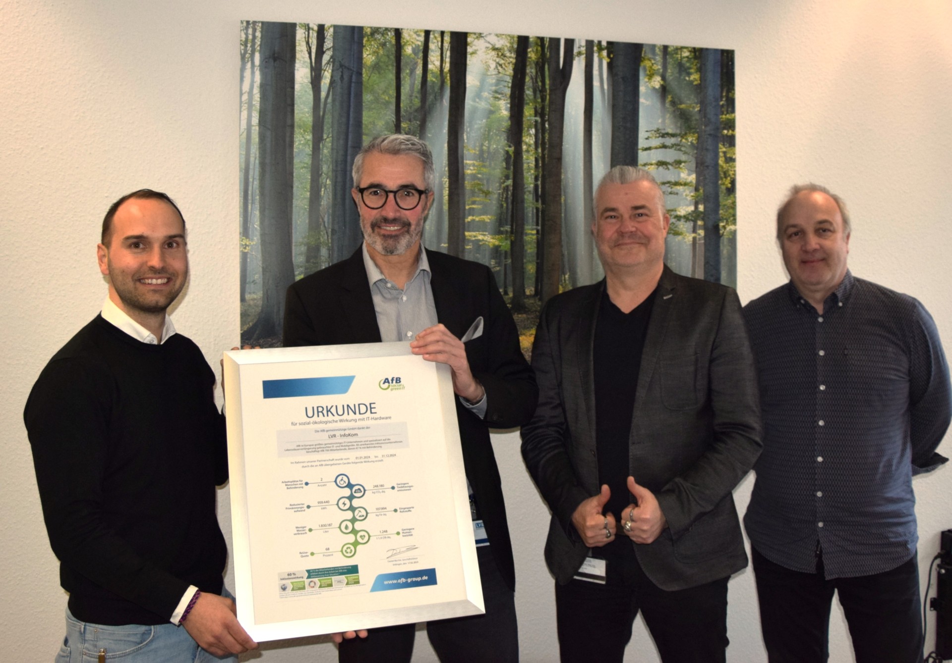 Im Bild sind vier Personen bei der Übergabe der AfB-Wirkungsurkunde zu sehen. 