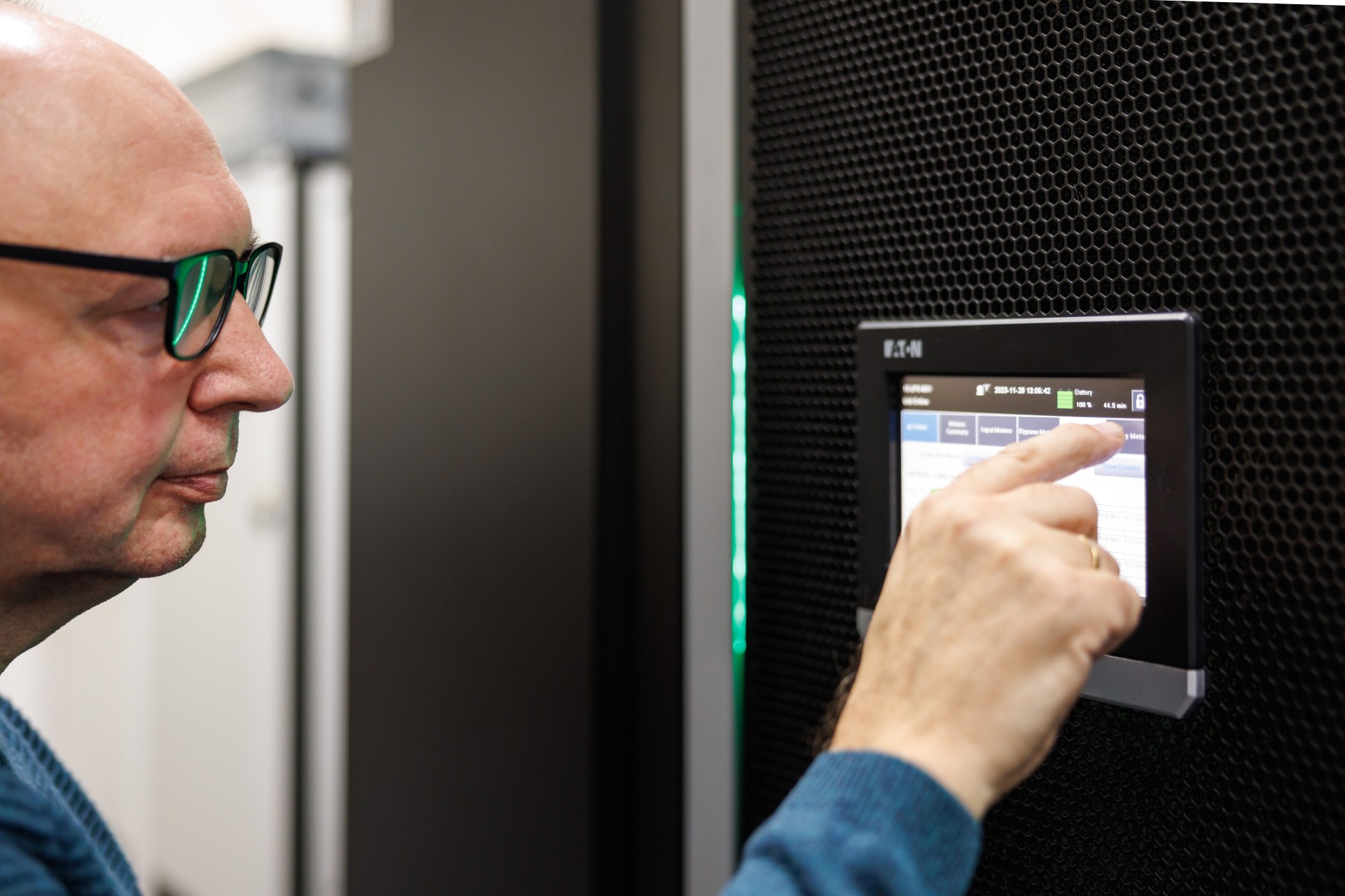 Mann mit Brille bedient einen Touchscreen