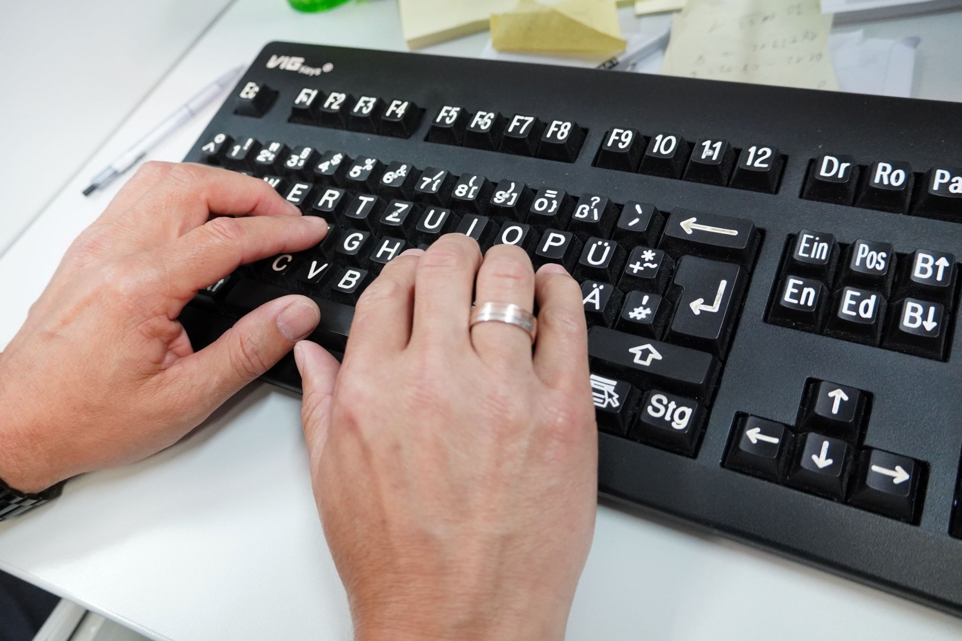 Zwei Hände an einer Großschrifttastatur