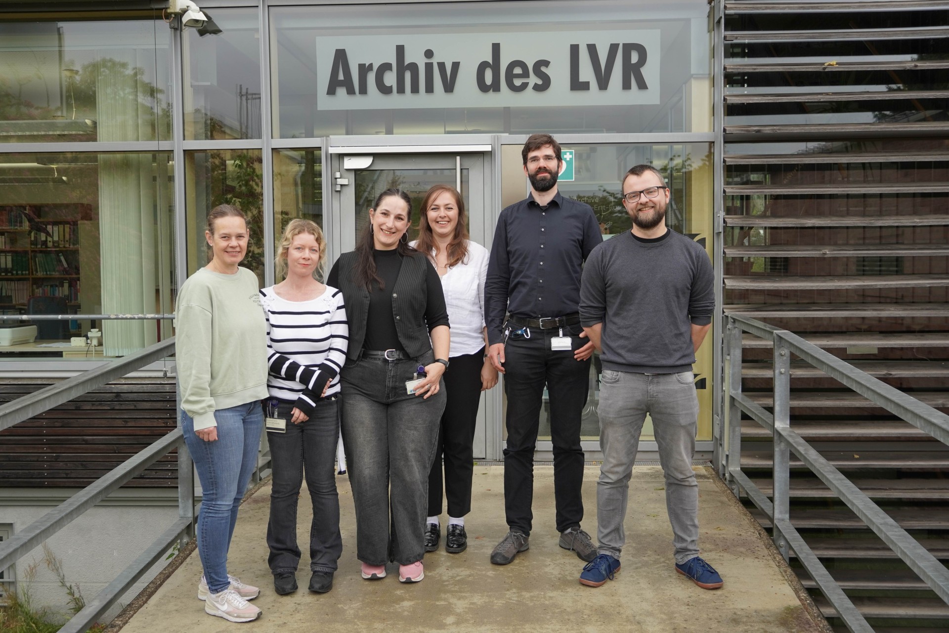 Sechs Personen stehen vor dem Eingang zum LVR-Archiv
