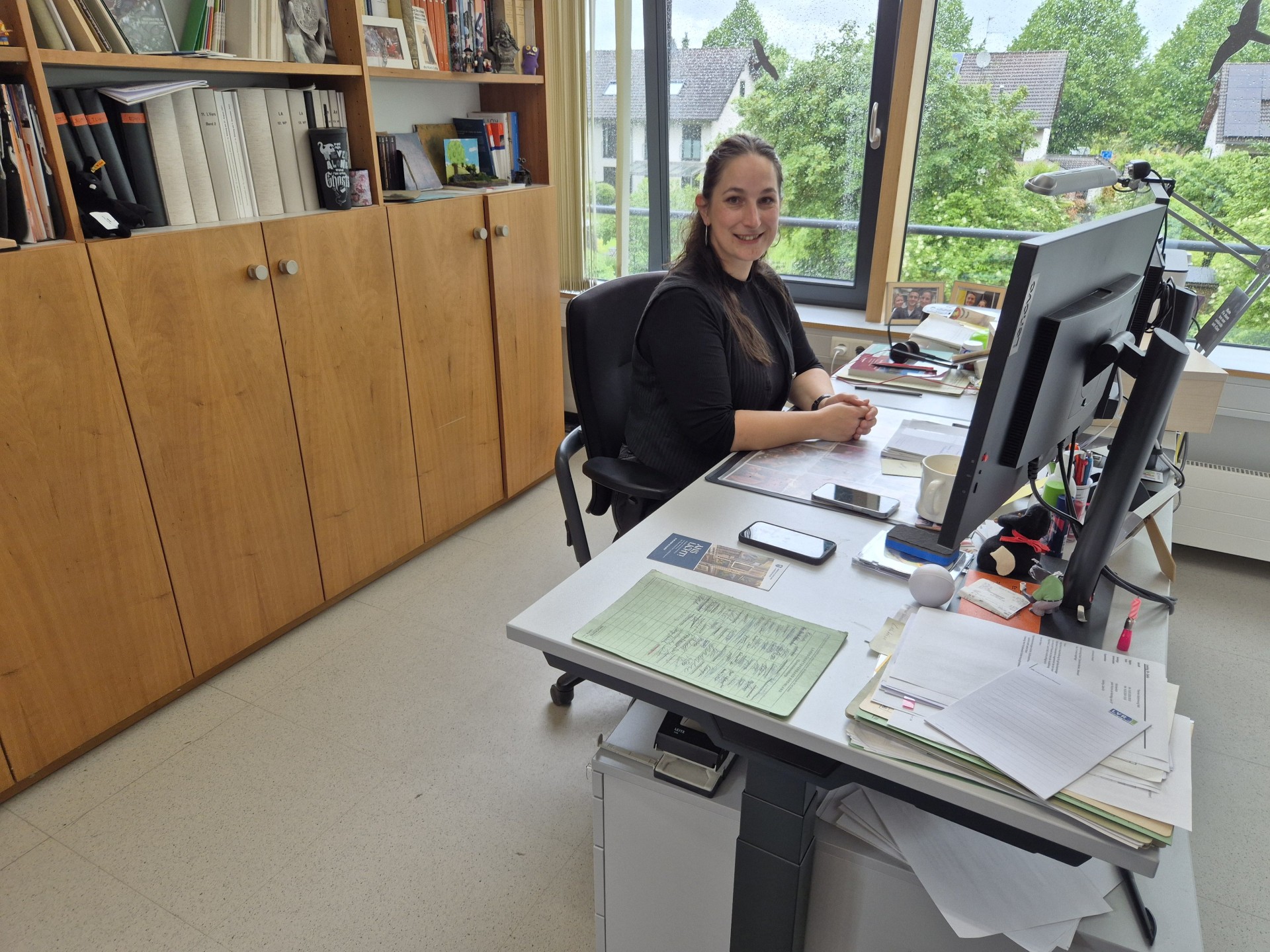 Eine Frau sitzt an ihrem Schreibtisch im Büro.